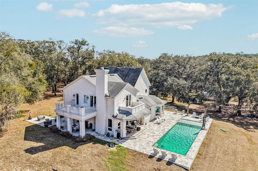 Looking for a Private Sanctuary nestled on just over 10 gentle rolling acres…  Look no Further! This Private Luxury Pool Home includes 4 Bedrooms (with separate office space easily used for 5th Bedroom) plus 3.5 Baths. The two-story traditional custom designed home offers unique features plus an expansive Saltwater Pool with Spacious Travertine Deck, BBQ area plus Portico Open to Front Patio and Rear Deck.  This unincorporated property is conveniently located near the impressive Black Bear Golf Community however, NO HOA.  As you enter, you will find your eyes are drawn to the exquisite Chandlier which adorns the foyer as well as the Circular Stairs, enhanced with Solid Wood Balusters leading to the 2nd floor. The 2nd Guestroom, just off the foyer, is currently used as the family TV Room. The extra wide 2nd floor Landing not only leads to the Master Suite and Upstairs Guestrooms, but it also includes a two-story Dumb Waiter plus convenient Laundry Shute to the downstairs spacious Utility Room. The Light and Bright Open “Eat In” Kitchen includes Dramatic Windows with amazing views, Beautiful Solid Wood Cabinetry with Granite Countertops, Built in Desk/Buffet plus Large Walk in Pantry.  the Kitchen is conveniently open to the Great Room with double French doors which leads to the Pool. The ½ Bath just inside the back door allows easy access as Pool Bath. A 300 gal buried propane tank supplies the kitchen Range and Tankless Water Heater (which could easily be converted back to electric) The Master Suite is located on the 2nd level and includes beautiful Ensuite Bath with Corner Soaking Tub plus Walk in Shower and two Walk in Closets. Double French doors open to a classic Balcony to relax and enjoy the morning gentle breezes or have a cocktail in the evening.  The Double-Sided Gas Fireplace offers warmth and cozy atmosphere and backs to the additional office space with built in shelving. Upstairs, the two Additional Guest Bedrooms share a spacious Jack & Jill bath plus one has a unique study/office/craft area. This Luxurious Home and Rolling Landscape can accommodate all Your Dreams…maybe a Quiet Oasis, Equestrian or Cattle Ranchland or maybe a Nursery. The irrigated Garden Area located near the Solar Field awaits your updates and design. You will notice this property also has a 3-car garage and additional parking pad to accommodate additional 3-4 vehicles plus a large Barn/Equipment Shed. The Roof installed 6/22'; Pool and Deck installed 10/17' Close to Mount Dora, Eustis and Tavares Shopping, Entertainment, Restaurants and of course the Chain of Lakes for all the Water Sports and Recreation. Easy Commute to Orlando International or Sanford International Airports - Don't Miss Seeing this Beauty!