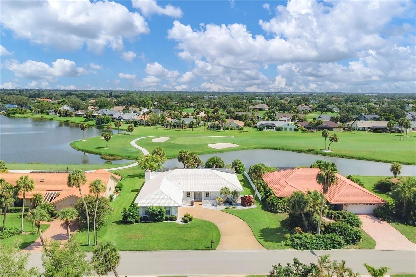Full of potential and ready for a makeover! A rare opportunity awaits in the guard-gated community of The Country Club of Sarasota. This home offers privacy, space, and breathtaking views of the lake and golf course beyond. Situated on a spacious, private lot in a highly desirable community. Flexible split floorplan and generous rooms throughout with over 2,500 SF of interior living space. Already completed: new Lennox A/C (2025), flat roof extension (2023), Rheem water heater (2022), pool cage (2022). Double-door entry leads to a large living room with a wall of sliders opening to the screened lanai and sparkling pool. Formal dining room flowing into the kitchen, ready for your vision, plus an oversized family room with wood-burning fireplace and access to a spacious enclosed Florida room. Private primary suite with two walk-in closets, ensuite bath and direct lanai access. Large guest room, full bathroom, laundry room, two-car garage and ample storage. Incredible screened outdoor space for entertaining with a covered lanai, sparking pool, and full pool bath for added convenience. Plenty of room for dining and lounging. Located in a well-established, beautifully maintained neighborhood with 24/7 staffed security. Residents also enjoy optional access to the Sarasota Sports Club with tennis courts, fitness center, junior Olympic heated pool, and more. Golf memberships at nearby TPC Prestancia are available but not required. All of this just minutes to world-famous Siesta Key Beach, The Legacy Trail, shopping, dining, the upcoming Sarasota Square redevelopment, and downtown Sarasota’s arts and culture scene.