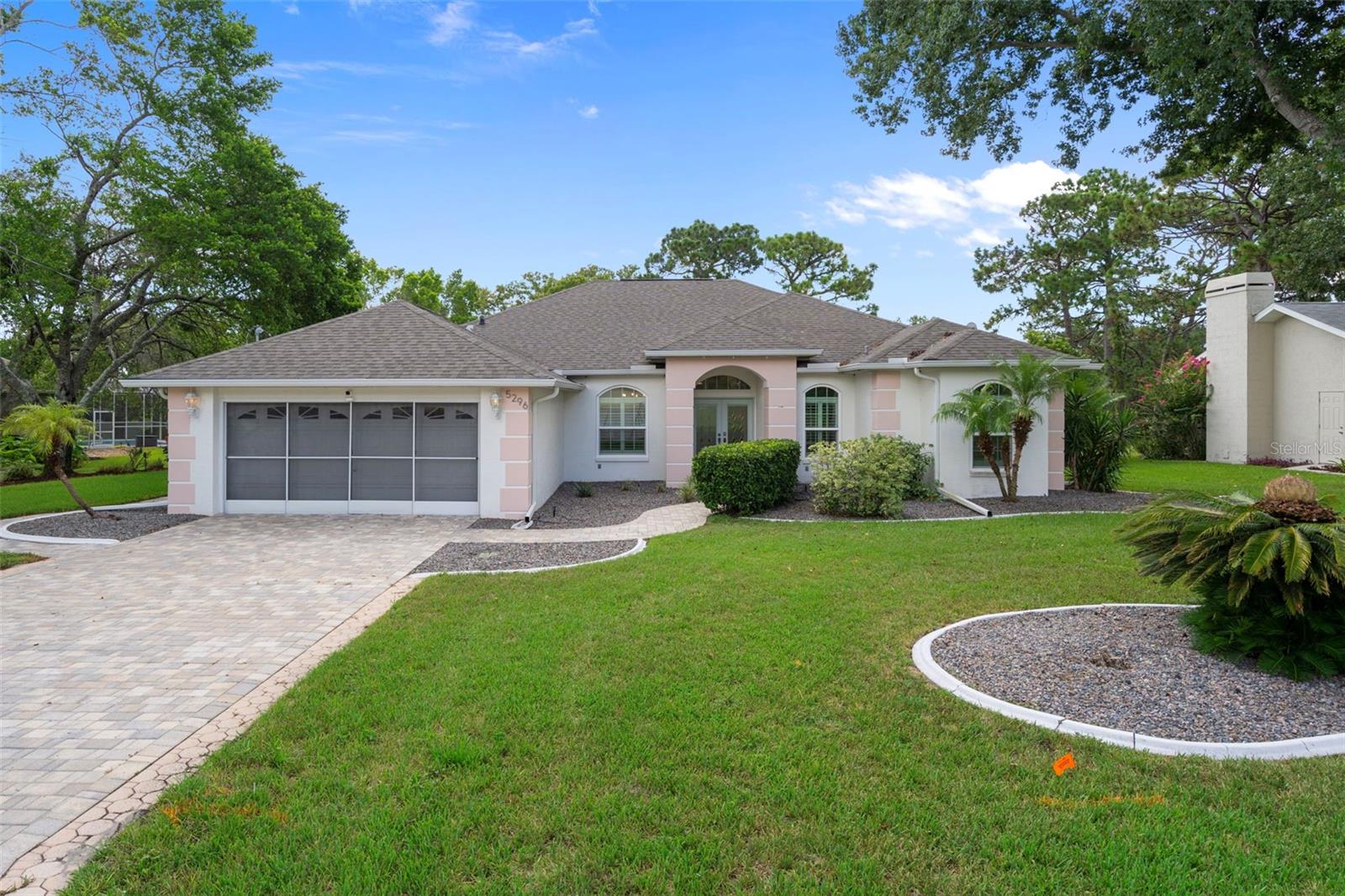 This meticulously maintained, gorgeous Alexander Custom-Built Home features three bedrooms, office, two bathrooms and an Oversized 2 car garage measuring 38.7 X 19.8. The home has a fully repaired sinkhole with all documentation and the home is is fully insurable. This Stunning Home is ideally located on the 15th hole of the Oak Hill Golf Course, offering sweeping views of the fairway and a lifestyle of elegance and comfort. There”s a beautiful paver driveway and lush and beautiful landscaping Step through the impressive double-doors with leaded glass into a spacious open floor plan and 2006 sq. ft. of living space and soaring 9-foot ceilings with a stunning double trey ceiling including recessed lighting and gorgeous upgraded fan/light. You will love the beautiful Armstrong plank laminated flooring, (throughout the home) creating an inviting and charming ambiance. There are Triple sliding glass doors from the living room that lead to an expansive screened in lanai complete with beautiful outdoor tiles. There is a custom made paver patio in the back yard complete with a gorgeous wooden pergola with amazing vines covering it and providing shade with built-in bench seating and a bar-height counter perfect for entertaining. There is a separate wooden deck with a gourmet Outdoor gas grill with marble top, storage and a refrigerator and it stays with the home. There is a very large shed on the side of the home perfect for all your storage needs. The beautifully landscaped, fenced in backyard with a golf course view boasts mature fruit trees and is maintained by an efficient irrigation system that utilizes well water. The home is painted in beautiful designer colors and other upgrades include central vacume system, gorgeous plantation shutters through out the entire home, New roof (2022), New AC (2022), New Windows (2020 ), a Vivint Smart Security System with Ring doorbell, keypad entry, cameras, glass break sensors, door and water sensors. The formal dining room is adorned with a modern chandelier and complements the inviting atmosphere. The gourmet kitchen is a chef's dream, featuring newer upgraded stainless steel appliances, bosch quiet dishwasher, a gorgeous range hood, recessed lighting, an abundance of beautiful white cabinets, corian counter tops and a walk-in pantry that offers ample storage and convenience. The breakfast nook has bay windows and custom made wooden wall panels that match the wooden wall panels on the breakfast bar. The master bedroom is a true retreat with a huge walk-in closet and sliding glass doors to the lanai. The master bathroom is beautiful with a large vanity offering lots of storage space and two white porcelain raised sinks, beautiful new mirrors, recessed lighting, relaxing jetted garden tub and separate step in shower. There is a bonus room/office, Nursery or home gym with a door to the master bedroom and a door to the living room. The Oversized garage measures 38.7 X 19.8 perfect for a workshop and there are pull down stairs to the attic, which has wooden flooring boards installed for more storage space. There is an inside laundry room with a sink, cabinets and washer/dryer. Both guest bedrooms have walk-in closets, and newer fan/lights providing abundant storage and comfort for everyone in the home. The guest bathroom has a step in shower, large vanity & french door with built in blinds out to the lanai. This Home is Located close to shopping, dining and doctors and its priced to sell for only $363,900.