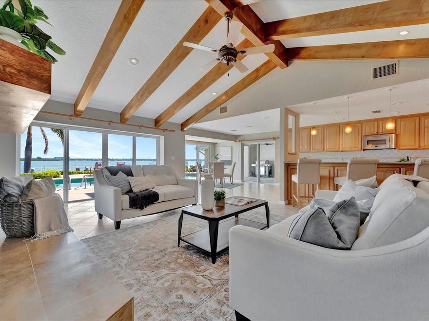 Experience waterfront luxury at its finest with this captivating 5-bedroom plus office, 4-bathroom Island Estates sanctuary boasting open water views. This residence welcomes you with panoramic views of the Intracoastal from the moment you step through the front door. Thoughtfully designed, the 3-way split plan ensures privacy and convenience for all residents and guests. At the heart of this home lies the spacious kitchen boasting solid wood cabinets, pull-out drawers, stainless appliances, an eat in kitchen space and a breakfast bar. Enjoy the incredible water views through the wall of sliding glass doors from the kitchen and family room that features a vaulted ceiling with gorgeous wood beams and a wood burning fireplace. Entertain effortlessly with the separate formal living and dining rooms. Retreat to the spacious primary suite offering breathtaking water views, several closets, and a walk-in closet with California Closets organizers. The primary ensuite bathroom was just renovated in 2020 and boasts sleek new cabinets, quartz countertops, a towel warmer, a luxurious BainUltra 2-person jet bathtub, and a curbless and frameless shower with a rain shower and multiple shower heads. You will have plenty of room for family and guests with the four secondary bedrooms (one is being used as a gym). In addition to the 5 bedrooms is an office found through glass french doors and lined with floor to ceiling built in wood shelves. Outside, indulge in the resort-style outdoor space with amazing water veiws and featuring a pool with Pebble Tec finish, top-of-the-line pool equipment with an electric and gas water heater, and LED lighting. The sizable composite dock with a boat lift and a 40’ slip awaits waterfront enthusiasts, providing easy access to the water. The fully fenced and landscaped back yard is an ideal spot to relax and entertain, creating a serene atmosphere that transforms everyday living into a perpetual vacation. Enhanced safety and conveniences provided with the hurricane-rated windows, doors, and sliders, along with a 22 KW Generac propane generator, gated courtyard and a hurricane-rated garage door. Additional notable features of the home include California closets in all the bedrooms, a media/security storage room, a large laundry room with expansive storage, 2 tankless propane gas water heaters, 2- 100 gallon propane tanks, LED lighting throughout, Lutron automated lighting control system, an oversized 2 car garage with overhead storage, automated and pull-down screens and a central vacuum system. Indulge in the epitome of waterfront living at this exquisite Island Estates residence. Enjoy the convenience of nearby shops and restaurants, with the added allure of a short bike ride to the stunning shore of Clearwater Beach. Current Flood Insurance policy is $3099/year.