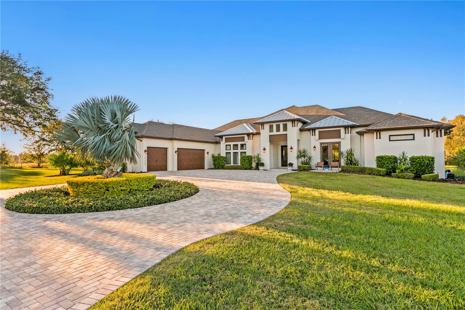 A true one-of-a-kind opportunity to own over 10 acres featuring a custom-built home, guest house, and two large barns. Nestled between Lake Frances and Lake Dan Nature Preserves and directly surrounded by untouched, protected ELAPP (Environmental Lands Acquisition and Protection Program) land, think of having over 3,000 acres of preserved land in your backyard, offering unmatched privacy and serenity. Enter the property through a landscape of timber pine, lush grass, manicured landscaping and expansive skies overlooking protected land. The main home, set on just over five acres, is luxurious from the moment you enter with sweeping views of the pool and uninterrupted nature through multi-slide hurricane-rated doors. The open floor plan is ideal for daily living and entertaining, with a chef’s kitchen that boasts leathered granite countertops, an oversized island, wine refrigerator, ceiling-height custom cabinetry and a butler’s pantry equipped with a Thermador oven, dishwasher and sink. The primary suite is generously sized for a California King and features two walk-in closets with custom built-ins, along with a spa-like bath offering a soaking tub and a double-entry shower. All baths feature granite countertops and walk-in showers, with two of the four additional bedrooms offering en-suite layouts and spacious walk-in closets. Additional spaces include a custom office and a spacious interior laundry room with cabinetry and a garment-hanging area. The lanai is an entertainer’s dream or a place to unwind, complete with an outdoor fireplace, summer kitchen and privacy. The pool area offers resort-style relaxation with a sunning deck, spa, mineral filtration system and customizable lighting to set the mood for any occasion. The property includes a 20-stall barn with baths, storage rooms and flexible configuration for horses. Adjacent to the main home, the guest house sits on its 5.49-acre parcel. This 1,555-square-foot home features three bedrooms, two baths, a large patio deck and a two-car garage. A second barn is also on this parcel, complete with a large concrete pad for equipment, electrical and plumbing. Notable upgrades include full generator wiring, maturing pine trees that can be harvested for timber, and hurricane-rated windows and doors. Just a half mile from the Lake Dan Nature Preserve, with a playground, lake, sunset views and over five miles of equestrian trails, this special property is unlike any other. It is your chance to own a beautiful, one-of-a-kind luxury equestrian estate. Less than 20 miles from Tampa International Airport and just off Tarpon Springs Road in Odessa, it offers rare privacy without sacrificing convenience. Adjacent lot of guest home and barn are sold with this parcel.