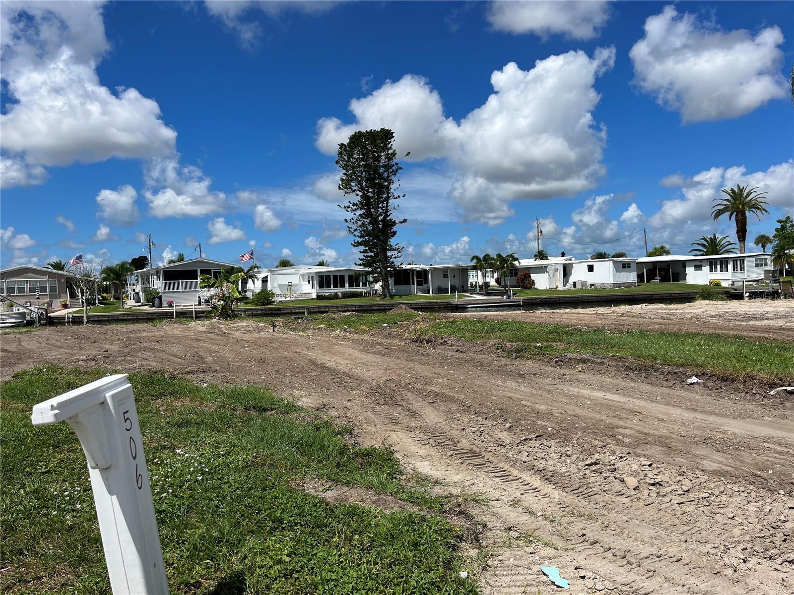 Discover your slice of paradise with this west-facing 50 x 88 vacant lot in the highly sought-after 55+ co-op community of Harbor Cove in Northport, Florida. Nestled on a serene canal, this prime location offers direct access to the Myakka River, perfect for boating enthusiasts and water lovers. Enjoy breathtaking sunset views from your future home, creating the perfect backdrop for evening relaxation. Harbor Cove is an active community brimming with amenities, including a sparkling pool, pickleball courts, tennis courts, a fitness center, laundry facilities, shuffleboard, a spa, a hot tub, and storage options, ensuring endless recreational opportunities. Imagine the possibilities as you design and place your own manufactured home on this lot, creating a personalized haven in a vibrant neighborhood. With access to golf and a variety of social activities, Harbor Cove provides the ideal blend of relaxation and active living. Don’t miss this chance to build your dream home in one of Florida’s premier retirement communities!
