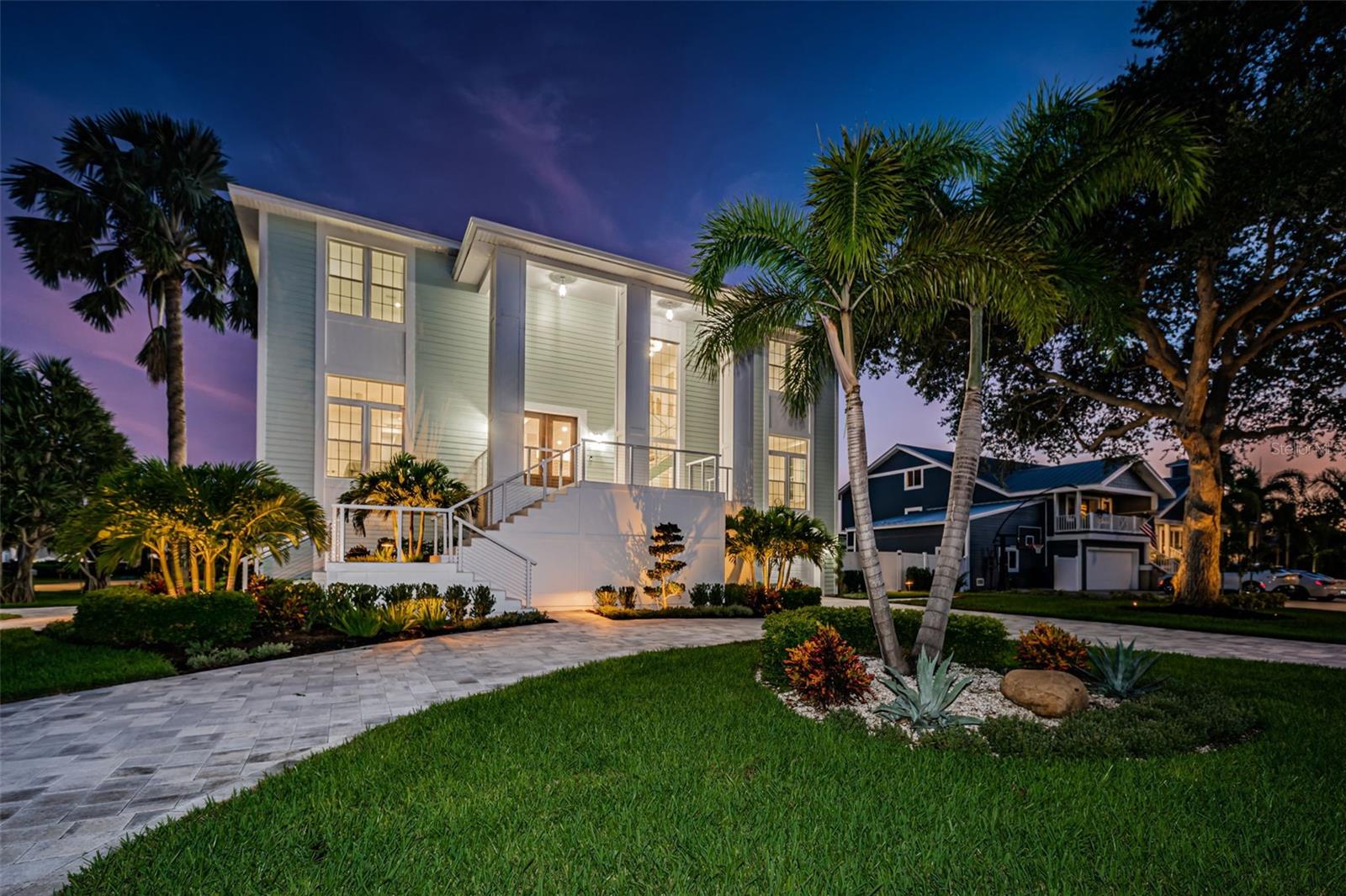 BRILLIANTLY AND DRAMATICALLY UPDATED IN 2023, THIS REMARKABLE COASTAL CONTEMPORARY ESTATE RESIDENCE PROVIDES A RICH, LUXURIOUS APPEAL! Lush landscaping, an attractive brick-paver circular drive and a towering 20ft-high covered entry welcome you to a home of captivating grace and beauty. Gorgeous wide-plank wood flooring, radiant modern lighting, high ceilings (several with splendid custom wood finishes) and an inspired open floor plan deliver an inviting and deeply satisfying living experience. The sumptuous chef’s kitchen boasts superb quartz counters, a grand, spectacularly finished island bar, top-of-the-line Café appliances, exquisite cabinetry, large walk-in pantry with matching cabinetry/counters and an elegant matching wetbar with beverage center. The impressive great room enjoys a terrific custom built-in LED fireplace and mantle with side storage/surfaces to match the kitchen. Large 26ft-wide 380sqft balcony overlooks pool deck is a great place for outdoor dining. A lovely guest bedroom and an engaging minimalist office (with private balcony) are supported by a fabulous guest bath with eye-catching tilework, waterfall quartz counter and large glass shower enclosure. Upstairs, discover a generous sitting room supporting 3 bedrooms. Stately owner’s suite has an exceptional custom walk-in closet system and an oversized, dedicated sitting area with private balcony. Your owner’s bath is a posh, pampering retreat – with beautiful tilework, lavish vanities with custom wall finishes, a fine soaking tub and a huge glass shower enclosure with 3 rain-shower heads and body wand. Attractive 2nd and 3rd upper-level bedrooms have closet systems and are supported by an alluring and well-appointed full bath. Step out to the private lower level and take in the pinnacle of multi-purpose entertainment – 300sqft+ covered sitting area with LED fireplace, 300sqft+ covered dining area with built-in SS kitchen/gas cooking center, and 470sqft covered poolside lounging area. Striking 2000sqft+ shellstone paver deck surrounds the dazzling swimming pool (with 40ft-long lap area) and hot tub. Superior laundry facility offers opulent finishes, LG washer/dryer & generous storage. Considerably oversized and tiled, the 3-car garage has lots of additional storage. Home is extremely well-built with all-block construction & poured concrete floors. Renovations are so thorough & complete that this home looks and feels brand new! A fantastic “easy living” luxury home!