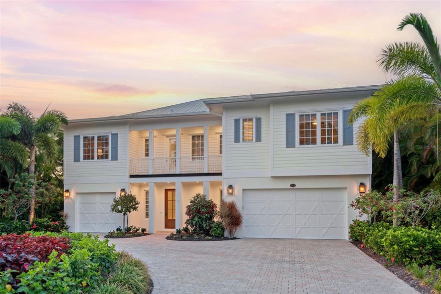 Situated in the tree-lined Buttonwood Harbour neighborhood on mid-Longboat Key, this beautifully appointed coastal waterfront masterpiece on 124 feet of deep boating water is just a short stroll to the tranquil Gulf-front beach. Built in 2013, the 3,413-SF 4-bedroom, 3.5-bathroom residence is nestled amid a private tropical oasis on protected Cranes Bayou, surrounded by flourishing landscaping with coconut palms, bougainvillea, birds of paradise, a stunning chenille plant and crushed-shell pathways. The .33-acre property includes a 7,000-lb boat lift with easy access to Sarasota Bay and the Gulf of Mexico. An expansive outdoor living area offers a travertine tile deck, oversized 35’ x 15’ heated saltwater pool, firepit and large covered patio – perfect for soaking in views of the water, sea life, magnificent skies and ever-present breezes. Inside, an elevator and American Black Walnut-clad stairs lead from the ground-level entry to the main floor, which showcases stylish open living spaces with the same walnut flooring, architectural details and plantation shutters throughout. The living room with pocketing glass sliders provides a seamless transition to a covered terrace with Ipe flooring, where you can relax and savor picturesque views of the bayou, pool and verdant grounds. Back inside, the centerpiece room features built-in white cabinetry with glass display shelves and volume ceilings clad with painted blue wood panels and gorgeous crown molding. The stunning kitchen features high-end appliances, including a Sub-Zero refrigerator, Wolf convection and steam ovens, Cambria Torquay quartz countertops and Brookhaven soft-close cabinets. Storage and entertaining space is continued with the handsome butler’s pantry and wet bar, featuring a Wolf microwave and wine refrigerator, and a walk-in pantry with additional refrigerator.  There is a spacious casual dining area surrounded by windows and glass sliders, and a separate formal dining room that exudes elegance and warmth with exquisite door mouldings and grass-cloth wallpaper. Bright and luxurious, the primary suite features a sitting area with custom draperies, French glass doors to the terrace, dual custom closets and a sumptuous bathroom with striking marble flooring, dual vanities with quartz counters, makeup area, walk-in shower with a bench and jetted tub. Two guest bedrooms with beautiful en-suite baths, gracious laundry room, and an office that could serve as a fourth bedroom with an adjacent powder bath complete the single floor main living level. The ground level includes two multifunctional spaces perfect for a bonus room and gym, abundant storage, 3+ car garage with Polyaspartic Flake flooring, and a side garage door for easy access to kayaks, SUPs, and all of your smaller waterfront toys. Other highlights include impact glass windows and doors, five smart TVs, 5-panel 8-foot-high doors and a 250-gallon underground propane tank. The Buttonwood Harbour community includes irrigation water in the low $600/year fee and also has a community dock with rental slips and a community boat launch. This coveted Longboat location is less than a mile from The Shoppes of Bay Isles, Publix, CVS, the Post Office, and the Longboat Key Public Tennis Center and just over a mile to the beautiful Bayfront Park, which has a dog park, playground, pickleball, tennis, basketball and shuffleboard courts.