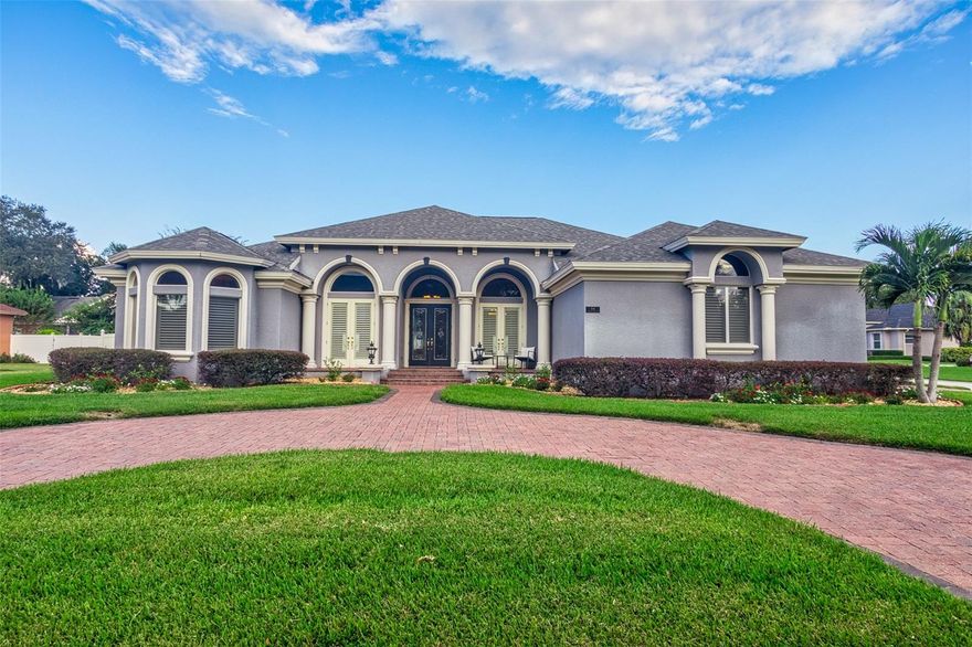 This stunning custom-built Tapia *Pool Home* is in the beautiful, gated community of Ashton Oaks. You will immediately notice the charming curb appeal of this home from the moment you drive up. It’s situated on a Large Corner Lot and boasts a Three-car garage with extra storage. Start at the paver driveway with updated landscaping and let the lovely Double Porches with French doors that flank the front of the home welcome you in. The stunning formal dining room with custom designed full-wall trim panels and two hand-painted Artisan ceiling Medallions are reminiscent of old-world Europe and elegance abounds. You will feel right at home from the sitting room, living room or kitchen that overlooks the saltwater pool and enjoy the electric fireplace in the family room, breakfast room and eat in kitchen bar. The open concept kitchen is fully equipped with Stainless Steel Appliances, Cooktop, Microwave, French Door Refrigerator, and Granite countertops with an eat in bar for you to enjoy your morning coffee or chat with your family and friends as you cook up a lovely meal. With stunning elegant details, such as high and coffered ceilings, recessed lighting, custom moldings and casing throughout, extra tall doors, 8-inch baseboard trim, freshly painted with thoughtfully selected colors, every detail has been impeccably executed. Take note that there is no carpet in the home, only the warmth of the lovely Bamboo wood or Travertine flooring throughout. Featuring a split floor plan, there are two additional bedrooms that share a bathroom at the rear of the home. There is a flex space room with plenty of closet storage, a bathroom with a separate exterior door, perfect for an In-law area or for long-term guests to have their own space or enjoy it as a game room, playroom or entertaining your friends during the sports or holiday seasons. The primary room is the definition of style and grace and offers the perfect retreat. Plantation shutters for neutral, natural light and recessed soft ceiling lighting and the view of the pool also make this area one of the most tranquil locations in the home. Move onto the bathroom that features double walk-in closets, a granite double sink vanity, garden soaking tub and a glass walk-in shower with rain head and two additional spray heads. The pool area is perfect for outdoor living. Relax and enjoy your beautiful, heated saltwater pool as the screened outdoor oasis provides ample space for family gatherings and for entertaining guests. The vinyl fence offers you all the privacy you need to soak up the Florida sunshine. The roof was replaced in 2023 and has a 10-year transferable warranty. The new AC heat pump was installed in 2022. Look no further as upgraded and impeccably kept home is going to be the perfect home for you.