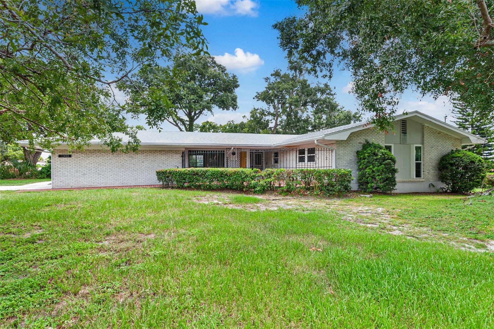 Timeless curb appeal, a walkable neighborhood and solid construction—this is the kind of home that stands the test of time. Perfectly situated on an oversized 0.38-acre corner lot, 1900 Manor Circle S.E. in Winter Haven, Florida, offers 3 bedrooms, 2 baths, and a spacious ranch-style layout that works beautifully whether you’re just starting out, growing a family or enjoying retirement.
Step inside and you’ll immediately feel a sense of warmth and character. The traditional floor plan includes a welcoming foyer that opens to both formal living and family rooms, filled with natural light and generous space for relaxing or entertaining. A practical and connected galley style kitchen flows easily into both living areas and the adjacent dining space—ideal for daily meals and family gatherings alike.
Down the hall, you’ll find expanded storage with a full wall of storage closets, a private primary suite with an en-suite bath and two additional bedrooms that are spacious and well-suited for guests, kids, or home office needs. A full hallway bath serves the secondary bedrooms with ease.
Outdoor living is equally enjoyable, with both front and back porches and a large screened lanai perfect for morning coffee or weekend gatherings. The oversized 0.38-acre lot provides plenty of green space, privacy, and room to garden, play, or expand. The 20x25 two-car garage is also oversized, offering room for vehicles, storage, laundry hookups, and space for a workshop or hobby area.
This home has been thoughtfully maintained over the years, with key updates made when needed. Notable improvements include new garage doors (2008), full home re-piping with CPVC plumbing (2012), energy-efficient vinyl replacement windows (2014), a 40-gallon water heater (2022), a full roof replacement (January 2025), and a new 3.5-ton HVAC system (April 2025). The structure is solid, the systems are sound, and the care is evident throughout.
Located in a quiet, established neighborhood with no HOA, this home is just minutes from Publix, shopping, banks, dining, medical facilities, and major roadways. Winter Haven—known as the “Chain of Lakes City”—boasts 50 interconnecting lakes, public boat ramps, scenic parks, Legoland Florida, and a vibrant downtown filled with events, restaurants and a weekend farmers market.
Centrally located between Tampa and Orlando, with Disney just 45 minutes away and both the Atlantic and Gulf coasts under 90 minutes, this home offers the perfect blend of small-town comfort and big-city accessibility. If you appreciate quality construction, a spacious layout, and a home that’s been cared for—not just flipped—this is one you won’t want to miss.
Schedule your private tour today and discover the timeless appeal of this Winter Haven gem.