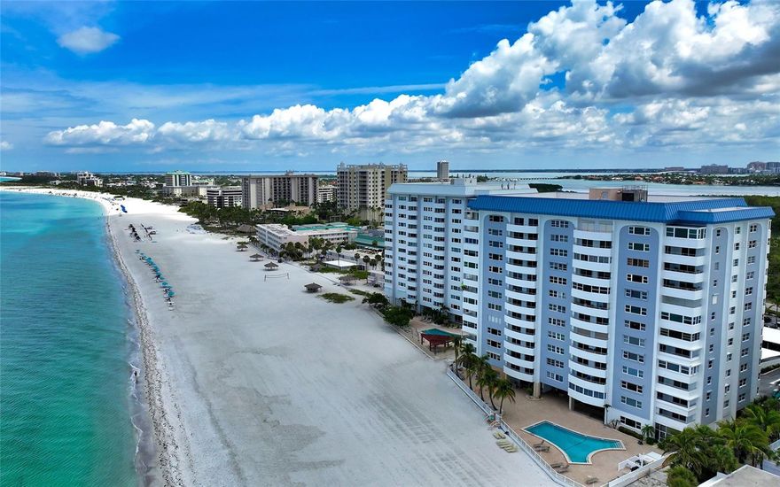 Lido Beach residence with expansive front-row views of the Intracoastal Waterway, Sarasota’s city skyline and golden sunrises. Experience the best of beachside living – without the heat! This inviting condo offers all the perks of a beach-front address, plus a unique advantage: its orientation keeps your space refreshingly cool, even on the sunniest Sarasota afternoons. Enjoy relaxing in comfort after a day at the beach, where cool comfort meets coastal charm. This expansive 2,035-square-foot residence has two bedrooms, two baths, a versatile den and a stylish open floor plan. The serene coastal palette, highlighted by seafoam blue walls and engineered hardwood floors, sets a tranquil tone throughout the home. The open-concept layout flows effortlessly from a solid wood and granite kitchen with stainless steel appliances and a built-in desk, into a gracious dining space anchored by a dry bar. An enclosed Florida room provides an additional light-filled retreat. The primary suite is a private sanctuary, complete with a sunroom, dual walk-in closets and an en-suite bath. A separate guest suite with its walk-in closet ensures space for family and friends. Additional features include impact windows throughout, two coat closets in the foyer, and two hallway storage closets. A shared utility room on the floor has an assigned storage locker, as well as a large-capacity washer and dryer. If you prefer to have in-home laundry, in-unit appliances are allowed. The first-floor community space was remodeled in 2025 and features lobby, fitness room, library and social room with kitchen for entertaining. First-floor amenities also include shower/saunas and bike rack storage. The beach-side pool area features an expansive deck for enjoying the Gulf-front location. Between the Gulf of Mexico and Sarasota Bay, Key Towers South sits on a prime piece of waterfront on south Lido Key. Lido Beach is your backyard. Just a quarter mile south is South Lido Key Park with outdoor activities and mangrove tunnels. One mile north is world-renowned St. Armands Circle with posh shopping, dining and nightlife. And four miles over the iconic Ringling Bridge is downtown Sarasota. The free Sarasota Bay Runner trolley takes you from south Lido to downtown Sarasota with multiple stops along the way.