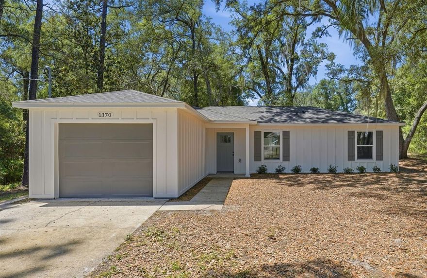 Practically a Brand New Home on an Oversized-Lot in a desirable Orange City Location with NO HOA!  All NEW features were completed in 2026 by licensed contractors, properly engineered & permitted and include: New Roof with all new decking and hurricane strapping, New HVAC - including all new ductwork, New Water Heater, New Electrical Panel Box & Service Box, New BOARD & BATTEN Hardie Siding, New Insulation & Drywall, New Windows & Doors including Garage Door & New Interior Finishes Including Flooring, Cabinets, Countertops, Doors & Trim, Appliances, Bathtub / Shower, Faucets & Fixtures etc.  From the moment you enter this home, you will be greeted with durable & waterproof luxury vinyl flooring, and a beautiful kitchen featuring white shaker cabinetry, stainless steel appliances, and granite countertops!  You'll appreciate the functional split floor plan, indoor laundry room & walk-in closet in the Primary Bedroom.  All paved roads will lead you to this gorgeously-wooded property, which is 60% larger than standard lots in this neighborhood and is the perfect setting for this modern farmhouse style home.
