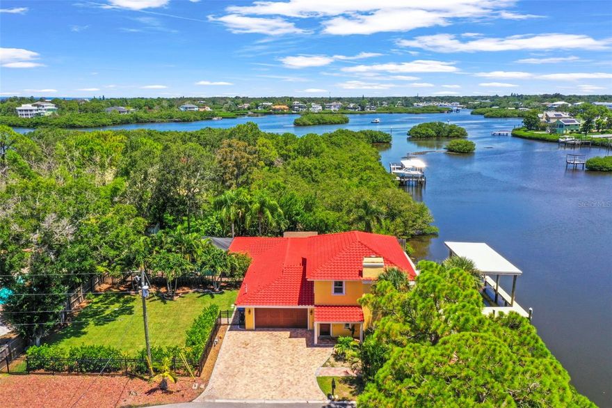 Nestled on a lot and a half along the serene waters of Southerland Bayou, this stunning waterfront home offers a private, nature-rich retreat in the heart of the quaint fishing village of Ozona. With 105 feet of water frontage, a new dock with a covered boat lift, and sweeping views of the bayou, this is truly a nature lover’s dream. Watch dolphins play, birds soar, and fish jump—all from the comfort of your own backyard. Step outside and enjoy a thoughtfully designed outdoor oasis, featuring a gas fire pit, grill, and arbor on the waterside—perfect for sunset gatherings. On the opposite side of the home, indulge in a self-cleaning, heated saltwater pool and spa set within an illuminated screened enclosure. Looking for a fenced yard ideal for both two-legged and four-legged family members, this home has that too. Inside, the home has been tastefully updated and is truly move-in ready. Upon entering, you’re immediately greeted by panoramic water views that bring the outside in. The living room with a cozy fireplace flows effortlessly into the kitchen and family room, making it easy to stay connected while entertaining or relaxing. The main floor includes three bedrooms, one of which features an ensuite bath—perfect for guests or multi-generational living. Ascend to the upper level to discover the expansive master suite, a true sanctuary with its own Juliet balcony, offering peaceful water views and a private escape from the world below. Whether you're hosting friends in the screened-in sunroom by the kitchen or enjoying quiet mornings with a coffee by the bayou, this home is designed for both entertaining and tranquil living.Boaters will appreciate direct access from Southerland Bayou to St. Joseph Sound, Three Rooker Island, HoneymoonIsland, Caladesi Island, and even Clearwater Beach. Located in golf cart-friendly Ozona, you’re just a short ride away from the Pinellas Trail, charming local eateries, and all the coastal character this beloved community offers.