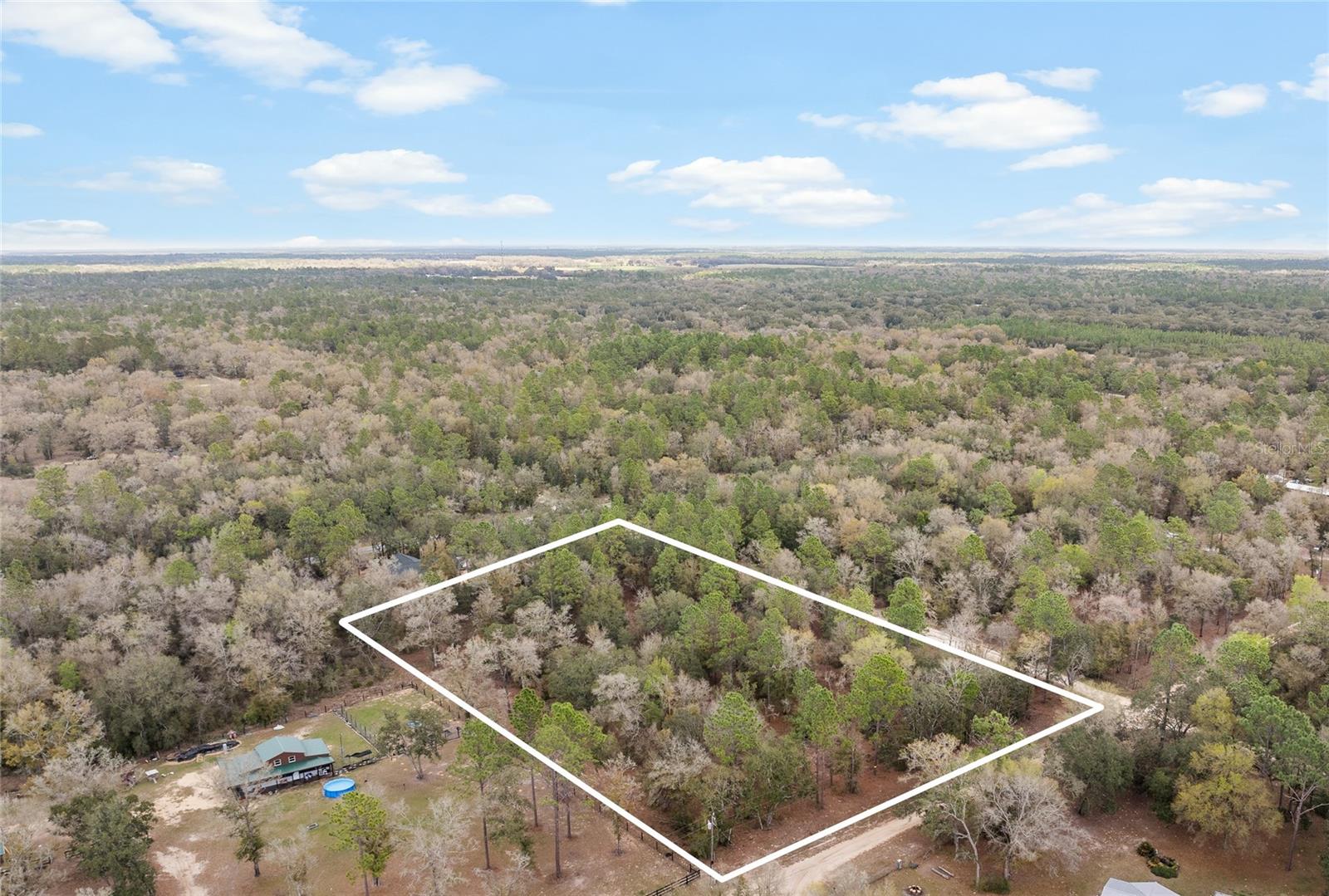 TRIPLE LOT only one lot away from the paved road, 80th Street. With over three acres, this would make a beautiful homesite and an amazing investment. Build one home or three and create a family compound! Bring the farm animals, start your garden, and enjoy your Florida land. Mobile homes and site-built homes allowed, outside of city limits with no HOA! The entire property is high and dry, no flood zone, meaning no flood insurance. Electric is right in front of property and so is fiber optic high-speed internet. This property is just five minutes to town, and easy commute to Gainesville, Ocala, or Newberry. You can even enjoy a nice drive over to Cedar Key for some fishing and delicious seafood, or to the beautiful! Take a short ride to the beautiful Devil's Den Spring or the Blue Grotto Springs! Purchasing these lots together gives long-term value as they can easily be resold in the future. Come check out this beautiful property and start building your dreams today!