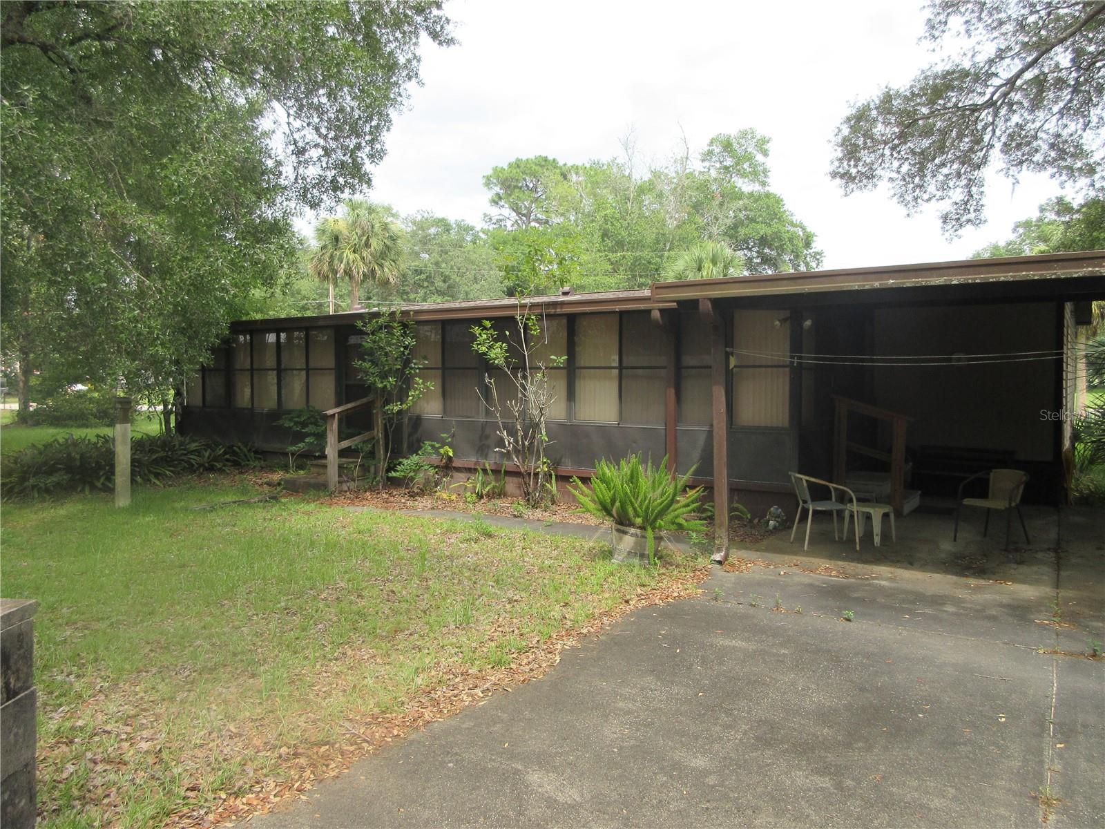 This property is totally livable. There are lots of cosmetic issues, but mostly new vinyl in master bath, bath tub repair in spare bath. Older roof needs replacing at some point. Home sits on a huge corner lot in neighborhood with lake access. Home is partly furnished and includes a 12x40 custom built room addition with A/C vents. Outside features storage building and a 20x23 custom built aluminum carport. A/C unit is 4 years old, other than the roof, just TLC is needed. Seller may give some allowance for new roof.