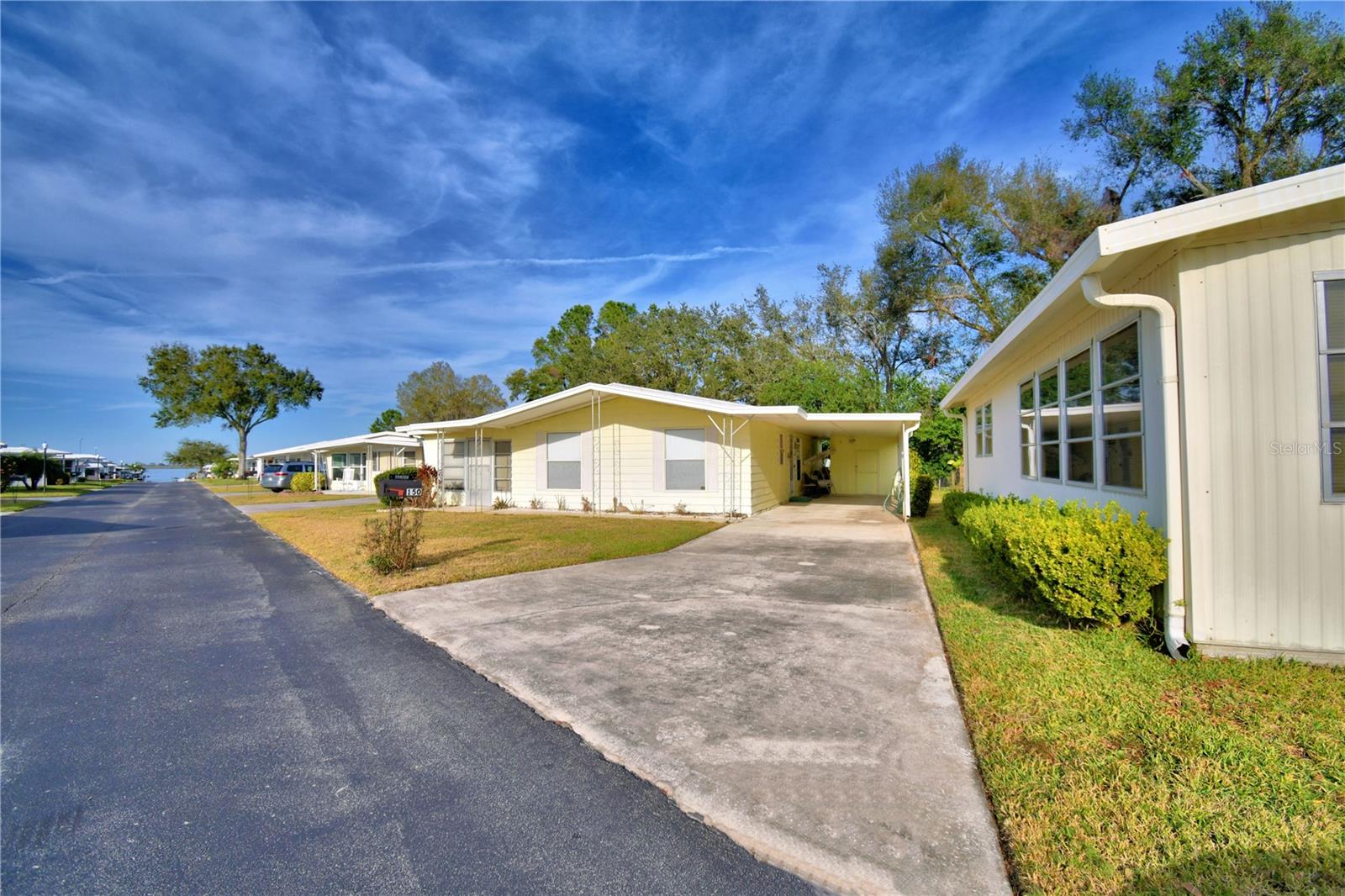 Welcome to your new Florida home. This almost 1300 square foot home is waiting for you. This home features two living areas. The bathrooms have been updated with newer vanities and the primary bathroom has a nice walk in shower, There is no carpet in this home, but has ceramic tile throughout. The home comes furnished less personal items, fishing equipment, kayak, lawn equipment, and tools. Ariana Shores is a peaceful 55+ community. Amenities include a pool, shuffleboard and boat ramp. The boat ramp is on Lake Arietta and if you cross the street, there is a pier on Lake Ariana, so you have access to two very nice lakes. Make your appointment today to see this home!!