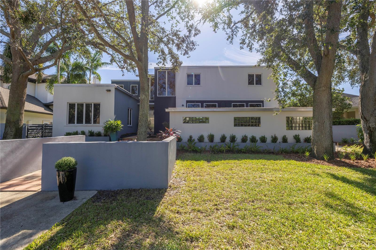 Designed by renowned Architect William Harvard Jr and built in 2005, this waterfront modern marvel boasts a beautiful layout and a wonderful view in a highly desirable location of Snell Isle. This home was built like a bunker, and was certainly tested during the recent storms, with no damage or interior flooding. The home sits above the flood plane, and the exterior walls are concrete block with filled cells, and with structural steel studs. Interior walls are also concrete block with prestressed concrete planks for ceiling and roof support. The floor construction is concrete under the beautiful hardwoods. The home also features a new roof in 2024, hurricane windows and doors throughout, and a whole house generator so you don't lose power in any storm. Beyond the best construction, this is an artist's home, where natural light fills the spacious rooms, and provides grand wall space with 10' ceilings on the first floor. Enter through the custom metal front doors into a two story foyer. To the left is a beautiful formal living room and large hall closet that could be turned into a butler's pantry or wet bar. The large first floor den also features a full bath, and could be used as a downstairs primary or guest room. For the ultimate entertainer, the formal dining room connects to the chef's kitchen, featuring a professional 6 burner Thermador range and large eat-at island with custom red quartz. The cozy family room features a gas fireplace and inlaid wood floors. Every living space features french doors that open to the Spanish tiled porch that spans the width of the home, the ideal place to enjoy the morning air or evening beauty of Coffee Pot Bayou. When it is time to retire for the night, take the elevator to the second floor, featuring 8' ceilings, wood and carpet floors. Three bedrooms upstairs all feature en-suite bathrooms with cast iron tubs, custom vanities and countertops, and waterfront views. Down the hall is a large laundry room with great storage. The master suite features a large walk-in closet and large bathroom with shower, garden tub, toilet room, dressing area, and custom double vanity. All bedrooms on the second floor have doors to two covered porches, where you can enjoy a morning coffee overlooking your private yard and updated dock on the bayou. The dock was rebuilt in 2024 and has both a boat lift and jet ski lift. A massive three car garage has high ceilings and bonus storage areas, and can accommodate a car lover's lifts for multiple vehicles and toys. Just minutes to downtown St Petersburg, this beautiful Snell Isle home was built to last, and its modern design make it timeless. Make your private showing appointment today!