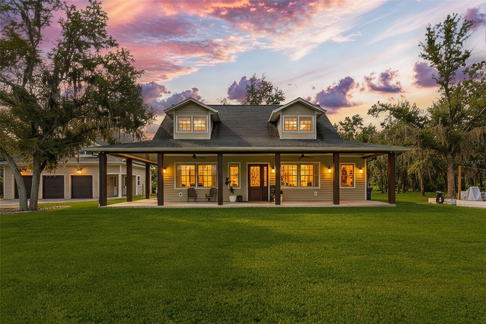 Feel welcomed by the scenic tree-lined country road where sunlight dances through the branches and horses, cows and rolling farmland invite you to a romantic, modern farmhouse with 2 stories and 2 buildings next to each other on a 4.13 acres lot filled with mature oak trees, a cute chicken farm and lots of private space. You will immediately notice the open 1100 sq ft front porch, and stylish fiber cement siding that create a warm, yet polished look. Inside the main house, a 20ft ceiling grabs your attention and an open floor plan awaits featuring a spacious great room with an electric fireplace and abundant natural light. The gourmet kitchen boasts quartz counter tops, stainless steel appliances, a large center island, custom cabinetry and a secluded butler pantry with more cabinetry and counter space. The kitchen shows both cozy, practical and a touch of modern luxury. The primary suite offers a private retreat with a spa-like bathroom featuring a soaking tub, glass enclosed shower and functional vanity. The luxury powder room, a washer and dryer and lots of storage spaces sit nicely tucked away between bedroom and living room. A beautiful crafted stairwell makes a statement the moment you walk in. Upstairs you will find a spacious loft, a charming bedroom and a full bathroom offering the perfect space for a growing family. The second home, with its own separate entrance, at a few steps away, features a 974 sq ft 3 car garage for tools, lawn mowers and tractors. Upstairs you discover a full secondary 1006 under air sq ft living space with one large bedroom, a bathroom, a laundry and more storage space. Want to be creative and turn this into a mother-in-law suite, a home office or even rental potential.......this space adds incredible versatility to the property. This nearly 5-acre lot is a nature lover’s dream, featuring majestic mature oak trees that provide shade and beauty throughout the property. Expansive lawn areas comes with plenty of space for play, entertaining, or simply enjoying the outdoors. A charming chicken coop, a thriving vegetable garden and many mature fruit trees make it easy to embrace a farm-to-table lifestyle right at home. Major roads and highways within minutes, 2 Publix's only 1 mile away. Many major grocery stores like Costco and Target just 15 miunutes away. Beautiful brand new park at walking distance. Lots of shopping and restaurants only 8 minutes away. Do not miss this one!
