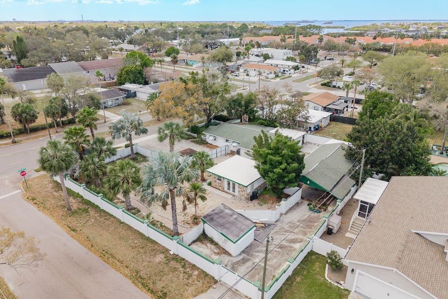 Situated on a one-of-a-kind 0.40-acre corner lot (137 x 125) in highly desirable downtown Palm Harbor, this property offers exceptional potential for investors, builders, or buyers looking to create their dream home. The double lot may have the possibility to be subdivided into two buildable lots (buyer to verify with the county), making it an outstanding development or investment opportunity. This property also features a fully renovated 2026 cabana complete with a kitchen and full bathroom, providing a functional and stylish space that could serve as a guest suite, entertaining area, or temporary living quarters during construction or renovation. Multiple outbuildings offer ample flexibility for storage, workshops, hobby spaces, or additional storage for your auto/boat/recreational vehicles, while the entire property is securely fenced and walled, providing privacy and versatility for a variety of uses. The existing home is ready for a complete renovation or  tear-down, giving the next owner the opportunity to design and build exactly what they envision while building equity in one of the area’s most sought-after neighborhoods. Location is everything, and this property delivers. This prime downtown Palm Harbor location is within walking distance to restaurants, bars, and local shops, and just minutes from the Pinellas Trail, Palm Harbor University High School, Crystal Beach, Delightful Downtown Dunedin, and the pristine white sands of Honeymoon Island. Located in a golf-cart-friendly community full of activities, this property is NOT DEED RESTRICTED and is in Flood Zone X adding even more value and peace of mind. Whether you’re looking for your next investment, development opportunity, renovation project, or a place to customize and call home, this unique property offers endless possibilities in one of Palm Harbor’s most desirable areas.