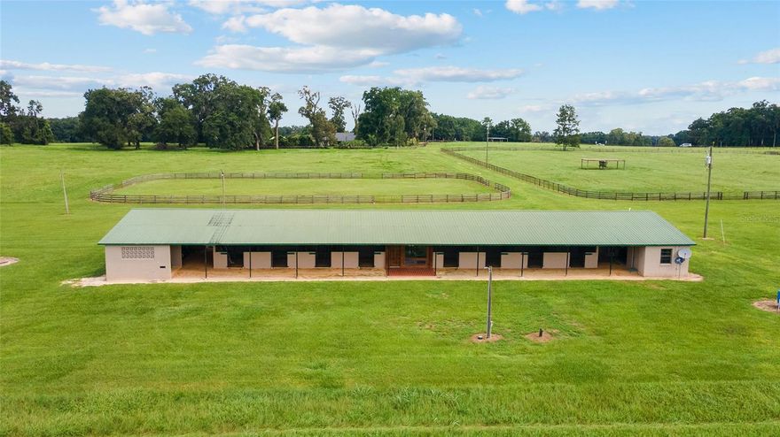 Discover the epitome of Country Living on this immaculate almost 90-acre farm in Northern Marion County Florida. Nestled in a picturesque setting, this property offers an unparalleled opportunity for those seeking a horse facility with plenty of high and dry pasture as well as privacy. The heart of the property is a block 16 stall barn equipped with wash stalls, tackroom, feedroom, storage areas, Office and kitchenette w/ bathroom providing everything necessary for your day to day operations. The expansive rolling fields surrounding the barns are beautifully maintained, currently producing hay. Amenities to the barn would be a level fenced arena, Workshop for tractor storage or hay, Full RV hook-up and a very large machine building building that can easily accommodate truck, trailer, tractors and more! At the end of the day you can relax in the well maintained 3/2 double wide offering a cozy atmosphere amidst the serenity of the countryside. Home has most current insurance requirements as well as a 2021 roof. This property is a rare gem, don't miss the unique opportunity to own this slice of paradise.