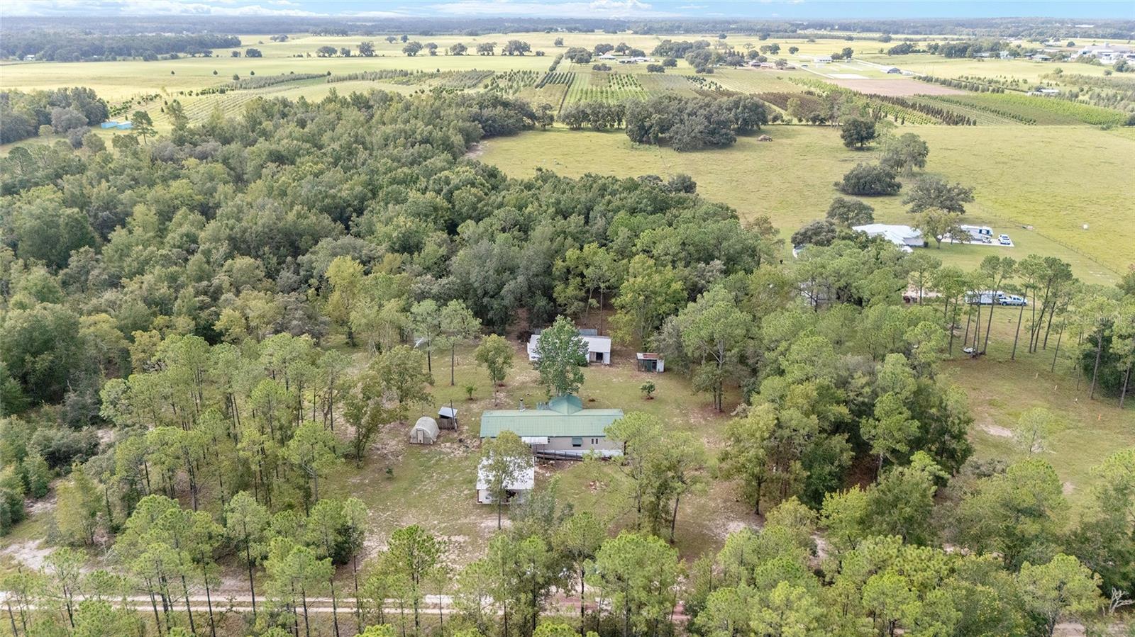 10.48 mostly fenced acres that are partially wooded and partially cleared with no HOA. The seller states this can be divided into multiple home lots per Marion County. Here is your own piece of serenity with plenty of space to do as you wish. The property features a 23'x48' outbuilding with electricity, perfect for use as a workshop, equipment storage, boat parking, or even a hobby space like a home gym or studio. The spacious home includes a living room with a fireplace, a family room, and a large kitchen for everyone to gather and cook together. The primary bedroom has 2 walk-in closets, and 2 full bathrooms. 1 bathroom has a garden tub, and the other bathroom has a step in shower. On the other side of this split plan are 2 guest bedrooms with new laminate flooring, and they each have a walk-in closet. No carpet throughout. The home also has a large walk-in pantry, and an inside laundry area. Enjoy mornings and evenings on the large deck facing the back yard, with room for grilling. Park your vehicles under the 23'x23' carport outside of the entrance to your home. Metal roof and AC are 2014, panel box 2024, and newer well. Information provided by the owner and public record.