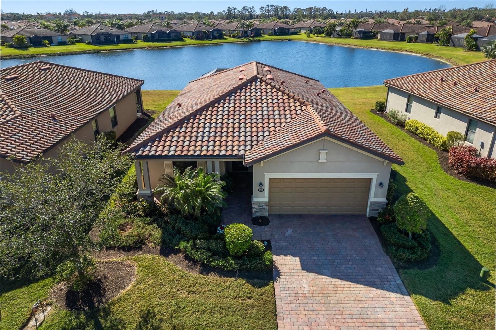 Welcome to 6517 Willowshire Way, a stunning single family home located in the distinguished River Strand community in Bradenton, Florida. This home offers the ultimate in maintenance free, resort style living, set on a premium lake view lot that showcases the natural beauty of Florida. This beautiful 3 bedroom, 3 bath Venice floorplan offers a PREMIUM LOT and salt water POOL for your year round enjoyment. The perfectly maintained home offers a split floor plan perfect for hosting guests. The open floor plan seamlessly connects the kitchen, dining, and living areas making it ideal for both everyday living and entertaining. Views of the outdoor oasis add to the open and breezy feel. The gourmet kitchen is chef's dream, equipped with granite countertops, brand new microwave and refrigerator, solid wood cabinetry, stainless steel appliances, and a large island perfect for meal prep and entertaining. Enjoy the refined touch of crown molding throughout the home, adding a touch of elegance. The primary suite offers a peaceful retreat with double walk-in closets allowing for plenty of room for everyone's wardrobe. The luxurious en-suite bathroom features separate shower and soaking tub. Step outside to your private backyard oasis, featuring a screened in lanai featuring an outdoor kitchen, and HEATED saltwater pool and spa, perfect for true Florida living to be enjoyed year round. The retractable screen allows for indoor/outdoor enjoyment of Florida weather. Spend your time with a view of the wildlife right outside your door, bald eagles, egrets, sandhill cranes, and ibises to name a few. The lush landscape and water views provide a peaceful and picturesque backdrop to your daily life. A home warranty is included to provided peace of mind for the future home owner! The Riverstrand community offers a wide range of amenities to enhance your living experience. The community boasts a beautifully maintained golf course, fitness center, multiple resort style pools, tiki bar, tennis courts, clubhouse with a restaurant and bar ideal for socializing and dining. The community offers a variety of events and activities. Don't miss the opportunity to make 6517 Willowshire Way your new address. Experience the charm and elegance of this exceptional property.