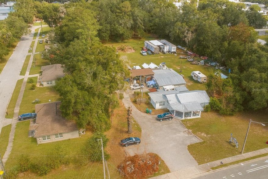 PRIME location of this unique commercial property - 2.34 acres zoned B2 with approvals in place for storage use facility/operations. Property features two versatile buildings with an estimated 16,800 AADT for maximum exposure along heavily traveled NE 14th Street/Bonnie Heath Blvd in Ocala's city limits. Front building serves as an office space with five offices, storage room, a break room with kitchenette and one bathroom. Rear structure combines storage capabilities, workshop area complete with car-lift AND living arrangements via a one bedroom studio apartment set up, with full kitchen and bathroom. Other features of property include, wooded canopy along the perimeter fencing for added privacy, makeshift retention pond supporting potential warehouse expansion and ample space for parking, storage, or future development. The B2 community business classification offers a wide array of potential uses for the property. Truly a unique opportunity for owner-users or investors, combining office, residential, storage, and development potential—all in a high-traffic NE Ocala corridor.