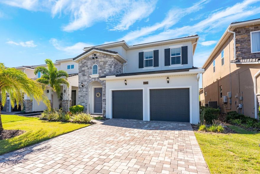 ***$40,000 SPORTS MEMBERSHIP INCLUDED W/ SALE!*** Ask about a lender provided RATE BUY-DOWN CREDIT on this home / Seller may consider buyer concessions if made in an offer ~ Welcome to luxury redefined in the highly sought-after, guard-gated golf community of Bella Collina – Orlando’s premier lakefront and golf destination! Set on a prime GOLF COURSE LOT, this 2022 BUILT modern retreat feels brand new, offering the perfect balance of elevated living and RESORT STYLE AMENITIES. Step inside to discover a fresh, thoughtfully designed interior with an OPEN CONCEPT layout that flows effortlessly from the chef’s kitchen to the living and dining areas. The kitchen is a dream come true – elegant custom cabinetry, crown molding, chic fixtures, sleek countertops, a backsplash that complements it all perfectly, and a large ISLAND with bar seating in a trendy contrasting color. Top-of-the-line STAINLESS STEEL APPLIANCES make this space both functional and beautiful. The MAIN FLOOR OWNER’S SUITE is a serene retreat, privately tucked away with sweeping GOLF COURSE VIEWS, a CUSTOM WALK-IN CLOSET, and a SPA-LIKE BATH with luxurious finishes. Upstairs, you will find spacious bedrooms – each with a walk-in closet, two full baths, and a VERSATILE BONUS/LOFT offering endless possibilities for additional living space, media room, or home office. Step out back to a COVERED LANAI complete with RETRACTABLE REMOTE CONTROLLED SCREENS, a fully equipped SUMMER KITCHEN with a vented hood, and the ultimate outdoor living space overlooking your sparkling HEATED POOL and SPA. The fenced yard backs up to panoramic fairway views – perfect for entertaining or soaking in your peaceful surroundings. Additional highlights include: a TESLA CHARGER in the garage, a whole-home GENERATOR HOOKUP, stone-accented exterior, and a paver driveway framed by lush landscaping for undeniable curb appeal. ****Living in Bella Collina means access to five-star amenities and an incomparable lifestyle spread across 1,900 acres of rare rolling hills and lakes. Residents will enjoy the Sir Nick Faldo designed golf course, scenic walking trails, resort-style pool, full-service spa, fitness center, tennis courts, two world-class restaurants inside the clubhouse, and more!**** Zoned for top-rated schools with easy access to the Florida Turnpike, shopping, dining and area attractions. Schedule your private tour today and experience the harmony of modern luxury and timeless comfort in a home where no detail was missed and every day feels like a vacation. Welcome to Vetta Drive and Bella Collina – where luxury, lifestyle, and HOME SWEET HOME meet!