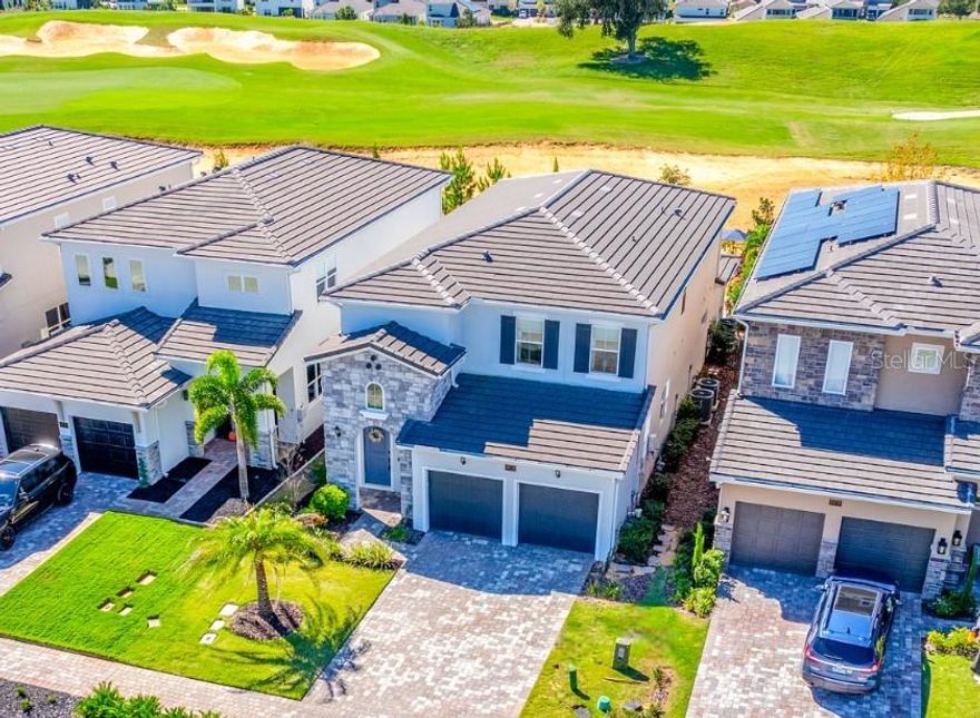 ***$40,000 SPORTS MEMBERSHIP INCLUDED W/ SALE!*** Ask about a lender provided RATE BUY-DOWN CREDIT on this home / Seller may consider buyer concessions if made in an offer ~ Welcome to luxury redefined in the highly sought-after, guard-gated golf community of Bella Collina – Orlando’s premier lakefront and golf destination! Set on a prime GOLF COURSE LOT, this 2022 BUILT modern retreat feels brand new, offering the perfect balance of elevated living and RESORT STYLE AMENITIES. Step inside to discover a fresh, thoughtfully designed interior with an OPEN CONCEPT layout that flows effortlessly from the chef’s kitchen to the living and dining areas. The kitchen is a dream come true – elegant custom cabinetry, crown molding, chic fixtures, sleek countertops, a backsplash that complements it all perfectly, and a large ISLAND with bar seating in a trendy contrasting color. Top-of-the-line STAINLESS STEEL APPLIANCES make this space both functional and beautiful. The MAIN FLOOR OWNER’S SUITE is a serene retreat, privately tucked away with sweeping GOLF COURSE VIEWS, a CUSTOM WALK-IN CLOSET, and a SPA-LIKE BATH with luxurious finishes. Upstairs, you will find spacious bedrooms – each with a walk-in closet, two full baths, and a VERSATILE BONUS/LOFT offering endless possibilities for additional living space, media room, or home office. Step out back to a COVERED LANAI complete with RETRACTABLE REMOTE CONTROLLED SCREENS, a fully equipped SUMMER KITCHEN with a vented hood, and the ultimate outdoor living space overlooking your sparkling HEATED POOL and SPA. The fenced yard backs up to panoramic fairway views – perfect for entertaining or soaking in your peaceful surroundings. Additional highlights include: a TESLA CHARGER in the garage, a whole-home GENERATOR HOOKUP, stone-accented exterior, and a paver driveway framed by lush landscaping for undeniable curb appeal. ****Living in Bella Collina means access to five-star amenities and an incomparable lifestyle spread across 1,900 acres of rare rolling hills and lakes. Residents will enjoy the Sir Nick Faldo designed golf course, scenic walking trails, resort-style pool, full-service spa, fitness center, tennis courts, two world-class restaurants inside the clubhouse, and more!**** Zoned for top-rated schools with easy access to the Florida Turnpike, shopping, dining and area attractions. Schedule your private tour today and experience the harmony of modern luxury and timeless comfort in a home where no detail was missed and every day feels like a vacation. Welcome to Vetta Drive and Bella Collina – where luxury, lifestyle, and HOME SWEET HOME meet!