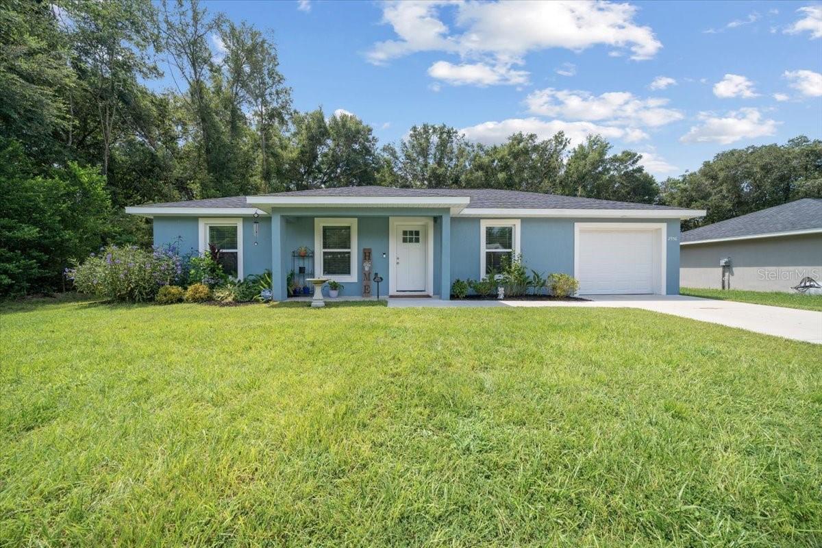 MORE PICTURES COMING SOON! Welcome home! This 2023-built 3 bedroom, 2 bath BLOCK-AND-STUCCO home in the quiet Summerfield neighborhood of Belleview Heights Estate, minutes from Belleview, Ocala, and The Villages is a home-owner's dream. Inside, you’ll find alabaster-white interiors, VINYL PLANK FLOORING, kitchen equipped with GRANITE COUNTERTOPS, vaulted ceilings, and an open layout filled with natural light. The dining room features SLIDING GLASS DOORS that lead to a private patio and yard with native flowers, a lime tree, and wooded surroundings. The primary suite includes a TRAY CEILING, walk-in closet, and en-suite bath with upgraded cabinets and Corian counters. Two guest bedrooms both with generous sized closets share a modern second bath. Additional highlights include an extended garage with EPOXY FLOORING, a large shed with dual AC units, an advanced WATER FILTRATION, and partial fencing for privacy. Conveniently located near shopping, dining, parks, and golf—this home combines comfort, function, and a peaceful setting, and will give you peace of mind, knowing the ROOF, HVAC, & HW are 2023, and WASHER & DRYER STAY! Don't miss out! Schedule a showing and make this charming home yours today!