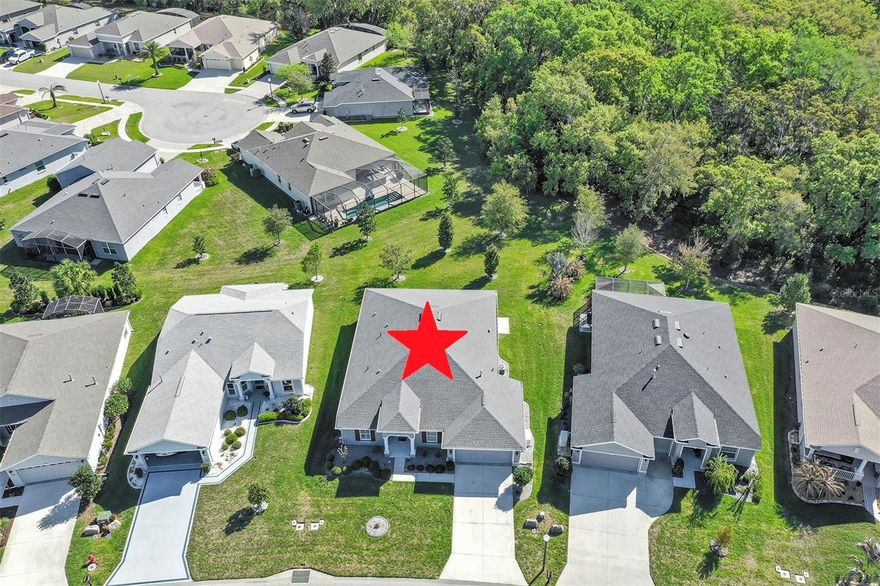 Welcome to a life that feels like vacation every day. Nestled in one of Central Florida’s most desirable resort-styled, guard-gated, active-adult golf communities, this beautiful, low-maintenance 2,034 s.f. conditioned Block & Stucco 3 Bedroom 2 bath home built in 2020 with luxury vinyl plank in all room except baths & laundry rooms have tile, over-sized 2 car stretched garage The home delivers the comfort, quality, and freedom you’ve been dreaming of on an over-sized lot big enough for a pool or big bird-cage lanai all without the resort price tag. Every detail has been thoughtfully cared for giving you peace of mind and more time to enjoy the things you love. The columns on the porch and glass entry door and 2 sidelight panels welcome you to the modern open concept home. Step inside and feel the spacious flow of the 21x16 great room with high ceiling and crown molding in all rooms to enhance your sense of space is perfect for relaxed evenings or lively gatherings with friends. The kitchen is equipped with side-by-side stainless steel fridge, high-efficiency quick-boil induction range, built-in wine cooler, nearby large closet pantry, double pull-outs on cabinet and soft close doors & drawers,  4-seat bar-top island that’s made for morning coffee and good conversation. ALL kitchen appliances stay. The owner’s suite has ensuite bath w/ walk-in shower, private toilet and walk-in closet. The split-bedroom layout offers privacy for you and your guests, Step out on to your 24x10 covered & screened lanai overlooking the conservation view and breathe in the tranquility of surrounding greenery while sipping your morning coffee or afternoon margarita or grille out on your lanai with natural gas grille that never needs re-filling, the indoor laundry room has abundant cabinets. The over-sized 2 car garage with golf cart garage, presently being used as an air-conditioned work shop can also be used for conditioned storage or a man cave, There’s also a natural gas powered whole house Generac 22kw generator you’ll never be without power. With the home’s energy efficient design including low-E windows, foam-filled insulated block and stucco construction, extra attic insulation, high-efficiency heat pump will save you money on your utility bill, The high construction standards and high elevation qualify this home for  massive insurance savings , this home offers beauty, strength and serenity in equal measure. But what truly sets this home apart is the lifestyle. Arlington Ridge is more than a community it’s a new way of living. Spend your mornings on the championship 18-hole golf course, your afternoons at the heated pools or fitness center, and your evenings with neighbors at the on-site restaurant, tavern, or free movie theater. Enjoy tennis, pickleball, billiards, or a peaceful stroll along golf cart-friendly streets lined with sidewalks and manicured landscapes. Low HOA of just $127/month, you’ll enjoy lawn care, high-speed internet, Wi-Fi & 200+ cable channels. With hardly any yardwork to worry about, What will you do with all your free time? Conveniently located near shopping, dining, medical services, and a short drive to Orlando’s attractions and both coasts’ beaches, this home blends resort-style living with everyday practicality. Don’t just buy a home, embrace the lifestyle you worked hard for and start living the life deserve. start living your best Florida life at Arlington Ridge. Retirement is not the end, it’s a new chapter just beginning