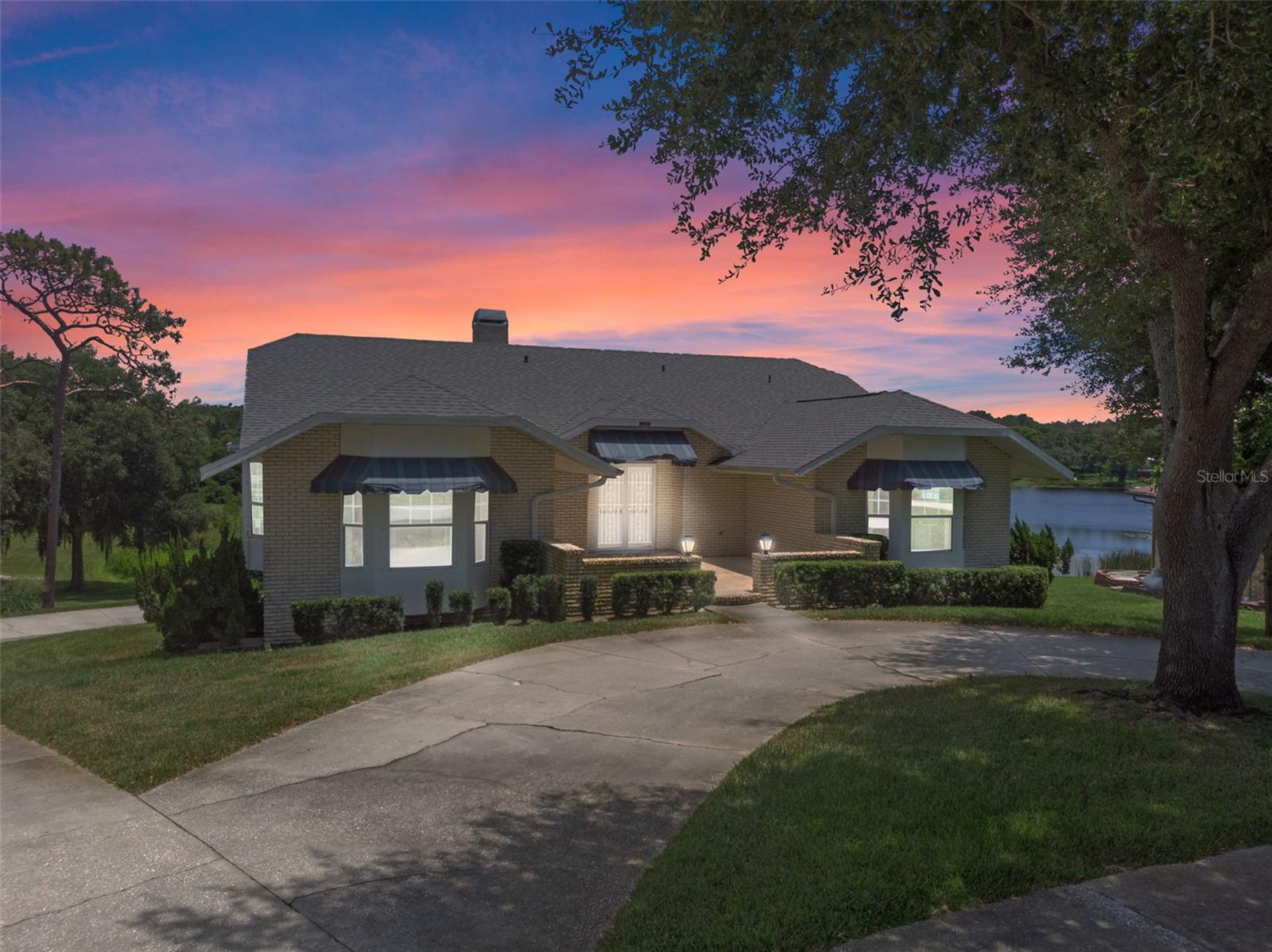 Lakefront Living with Space to Spare! Discover this one-of-a-kind lakeview property located at 34407 Black Bass Cir in Fruitland Park, offering the perfect combination of comfort, functionality, and serene natural beauty. This spacious 3-bedroom, 2-bathroom home features a Florida room running the full length of the back of the house, with large windows showcasing breathtaking views of the lake. While the Florida room is not air-conditioned, it offers a peaceful retreat with natural light and direct access to the small deck overlooking the water. Enjoy cozy evenings by the wood-burning fireplace, and benefit from recent upgrades including double-pane, tinted windows, a 2019 hot water heater, and a new roof installed in March 2025. The home is equipped with city water plus a private well for irrigation, maximizing efficiency and flexibility. A true standout feature is the immense garage—located below the main living area—with room to park up to 8 vehicles. It includes two 2-car garage doors, epoxy-coated flooring, and approximately 8 inches of insulation above to help maintain temperature. Two additional air-conditioned rooms off the garage provide excellent space for a workshop, hobby area, or office. Outdoor and travel enthusiasts will love the dedicated RV charging outlets, both inside the garage and on the exterior pad. Access to the lake is available directly from your property via the center gate marked by the white post, making this a true lake-lovers' paradise.