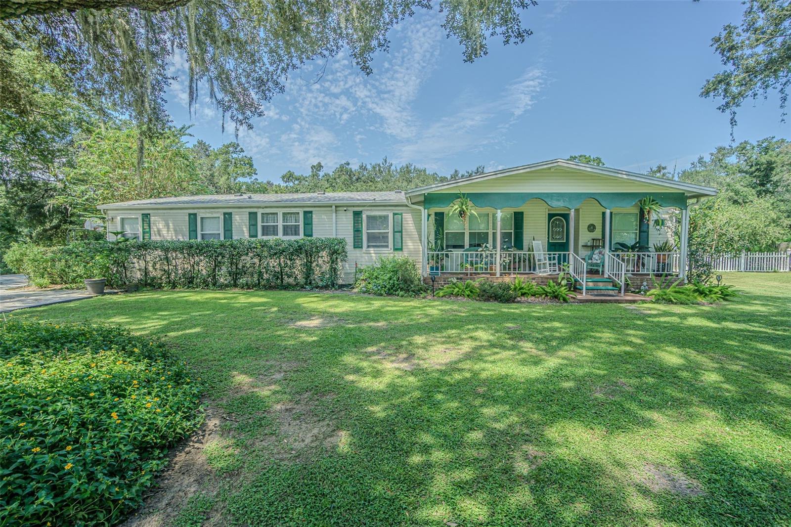 CLASSIC Brick and Wrought Iron Entry Welcomes you to this beautifully maintained and thoughtfully updated 4-bedroom (PLUS Office/Den), 3-bath home offering 2,008 square feet of comfortable living space on a fenced 1.11 acre lot in a serene, park-like setting. From the moment you arrive, the charm is undeniable... beginning with a rocking chair front porch overlooking front landscape and a leaded glass front door that sets a warm and welcoming tone. Step inside to a light, bright, and open floorplan featuring luxury vinyl plank flooring throughout (2021) and a spacious split-bedroom layout that offers both functionality and privacy. The expansive gathering room IS OPEN and connects to the kitchen, making it ideal for entertaining family and friends! The kitchen boasts a large center island, updated Stainless steel appliances, white and gray two tone cabinets, undermount sink and eat in dining space. A cozy wood-burning fireplace anchors the living room, creating a perfect spot for relaxing evenings. The primary suite is a true retreat, offering an enormous walk-in closet, a private vanity space large enough to serve as a home office or nursery plus a beautifully updated ensuite with ceramic tile. The second Bath features a skylight, filling the space with natural light. REST EASY and Enjoy the outdoors year-round with a 12' x 18' screened back porch overlooking your private, fenced backyard, complete with a firepit area plus a 24' round above-ground pool with wooden sundeck—ideal for summer fun. Additional highlights include a huge detached 24’ x 24’ garage with cathedral ceilings, dual garage doors, and a finished interior... perfect for a workshop or hobby space. You’ll also appreciate the arbor leading from the driveway to your private retreat, large storage shed, 2021 Craftsman 30-gallon water heater with a 4-ton, 14 SEER Tempstar HVAC system installed in 2022. A new dimensional shingle roof was added in November 2024, offering efficient utility bills and peace of mind for years to come. This property has NO CDD fees, NO HOA fees and is on well and septic, offering lower utility costs which provides the perfect blend of peaceful country living, city close, with modern updates. With its Light, bright, SPACIOUS floorplan boasting flexible spaces and inviting outdoor features, this home truly has it ALL! Located on a quiet lane in Zephyrhills, with major highways nearby for easy access to Lakeland, Wesley Chapel, Tampa, shopping, restaurants, medical facilities, airports and Florida beaches! CALL TODAY!