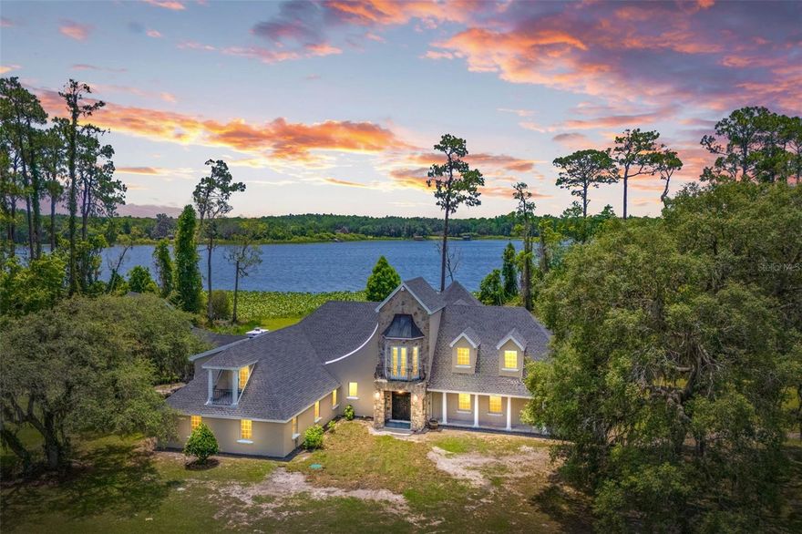 Now offered with 26 acres with an additional 50 acres available! Welcome to an EXTRAORDINARY lakefront estate where refined living meets natural beauty! Located on expansive 700 acre Lake Dias, excellent fishing and watersports are just steps away. Unmatched privacy is provided by over 2100 feet of available lake frontage and adjacent protected lands. This rare offering provides panoramic water views
and abundant space for outdoor enjoyment. Including an extraordinary barn and fenced pastures, whether you're seeking a multi-generational retreat, a private equestrian haven, or simply a peaceful escape surrounded by nature, this property delivers it all. The main residence combines modern luxuries and thoughtful updates throughout and incorporating imported antiques such as a 14th century gate and 17th century urn, English pub door, antique brass door hardware and more. One of the most valuable features of the home is the private mother-in-law suite, offering a comfortable and fully independent space for extended family, guests, or multi-generational living. Outside, the home is designed to embrace its natural surroundings, with multiple covered patios, wood plank ceilings, and serene views of the lake and grounds. An extraordinary mortise and tenon barn stands as both a functional and architectural masterpiece, with five oversized 12x14' stalls, hay storage, and floor drains in every stall. This home is built for comfort and longevity, with a brand new roof (2024) with transferable warranty, new septic system, a new hot water heater, and includes an air conditioned garage. The property is serviced by a well with an extensive water treatment system, including a proportional chlorinator, carbon filter and water
softener to supply the freshest, cleanest water possible. Nature lovers will appreciate the abundant wildlife—deer, turkey, quail, bobcats, otters, bald eagles, hawks, owls, sandhill cranes, and more all call this property home. Adjacent lands to the east are protected while lands to the west are in the final stages of being placed in conservancy. A garden containing a large mulberry tree, peach, loquat and fig trees
provide a bountiful harvest. The stocked pond supports a growing fish population, perfect for peaceful afternoons by the water. Offering the rare combination of luxury and privacy, this one-of-a-kind property is being sold furnished and includes a tractor and zero-turn mower—everything you need to immediately begin living the lifestyle you've dreamed of. Opportunities like this are exceedingly rare — come
experience the magic of this extraordinary lakefront retreat for yourself and schedule your private tour. This home may be under audio and visual surveillance.