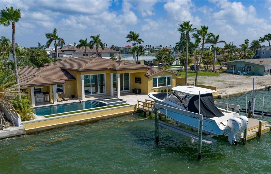 Paradise found on Boca Ciega Bay. Exceptional home located in one of the most desirable neighborhoods in St. Pete Beach. This custom rebuilt home represents a dream fulfilled.  Throughout an extensive renovation, the owners carefully thought about every detail in designing the perfect luxury home for their family where all of their needs were met.  5 Bedrooms, 4 bathrooms, approximately 3000 sq. ft. of heated living space all on one level. Expansive & sensible open floor plan with 12 foot soaring ceilings, 10 Foot hurricane rated impact resistant sliding glass doors allow the intoxicating water views of Boca Ciega Bay to enter into their home. Relaxing owner’s retreat. Resort Style Pool & Spa with covered patio & outdoor kitchen. Fireplace, Laundry room, Butler’s pantry & 2 car garage.  This home has it all. Located in the heart of St. Pete Beach, close to local dining, entertainment, shopping and one of the most beautiful white sandy beaches along our coastline with easy access to the interstate, Downtown St. Petersburg, the Tampa Airport & more. Please see the full feature sheet as there are too many features to list.  It will be difficult to find a more comfortable floor plan.(See floor plan attached)  Enjoy the aerial video to gain a true understanding of this breathtaking waterfront location on Boca Ciega Bay, just Steps to the Beach. Although this is a hard house to say goodbye to, the owners are ready to pass this very special home on to the new owners.  Are you ready to fulfill your waterfront dream?  After viewing the virtual tour, call today for a personal tour.