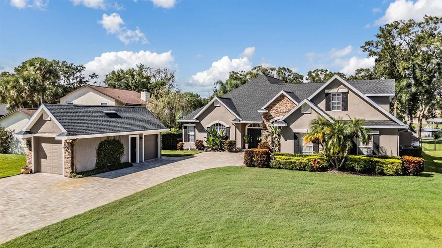 Welcome to this one-of-a-kind waterfront estate in the highly sought-after Lake Padgett community, offering deeded water rights on two parcels that extend directly into the lake, a rare ownership opportunity for both land and water rights. The home has been updated for peace of mind with a new roof, newly screened enclosure, and a rebuilt dock with upgraded decking and roof. Parking and storage are a dream with an attached two car garage, a detached one car garage with a soaring 9 foot door, plus an additional golf cart garage tucked behind the detached bay. Step through the front door into more than 3,200 square feet of heated living space, where tall ceilings and expansive windows create a bright and welcoming atmosphere. The main home features four bedrooms and three bathrooms, including a private upstairs bedroom with its own bath, perfect for guests or multi-generational living. The kitchen is the centerpiece of the home, offering rich wood cabinetry, granite countertops, a central island, stainless steel appliances, a built in wine rack, and plenty of counter space. From here, the floorplan flows easily to both casual and formal living spaces, all oriented toward the water. The primary suite is spacious and serene, with crown molding, a spa like bath, and a custom built walk in closet. Secondary bedrooms provide flexibility for family and guests. Plus a sperate office space downstairs. Outdoor living is where this estate truly shines. The screened lanai opens to a resort-style pool and spa with rock waterfall and lush landscaping. The outdoor kitchen is fully equipped for gatherings, featuring a built in grill, a large Green Egg smoker, fireplace, mini fridge, and a mini sink with running water. Above the lanai, accessible only by a private exterior stairway, is an additional 500+ square foot bonus room, complemented by a second story deck for elevated entertaining. This is a versatile space ideal for a game room, poker lounge, theater, or cigar room with its own mini-split AC. Life here means direct access to Lake Padgett’s three lakes, well-known for boating, skiing, and fishing, along with the privacy and space of a rare waterfront estate. This home blends thoughtful updates, rare land and water rights, flexible living spaces, and true resort-style outdoor amenities, making it an incomparable offering in Land O’ Lakes.