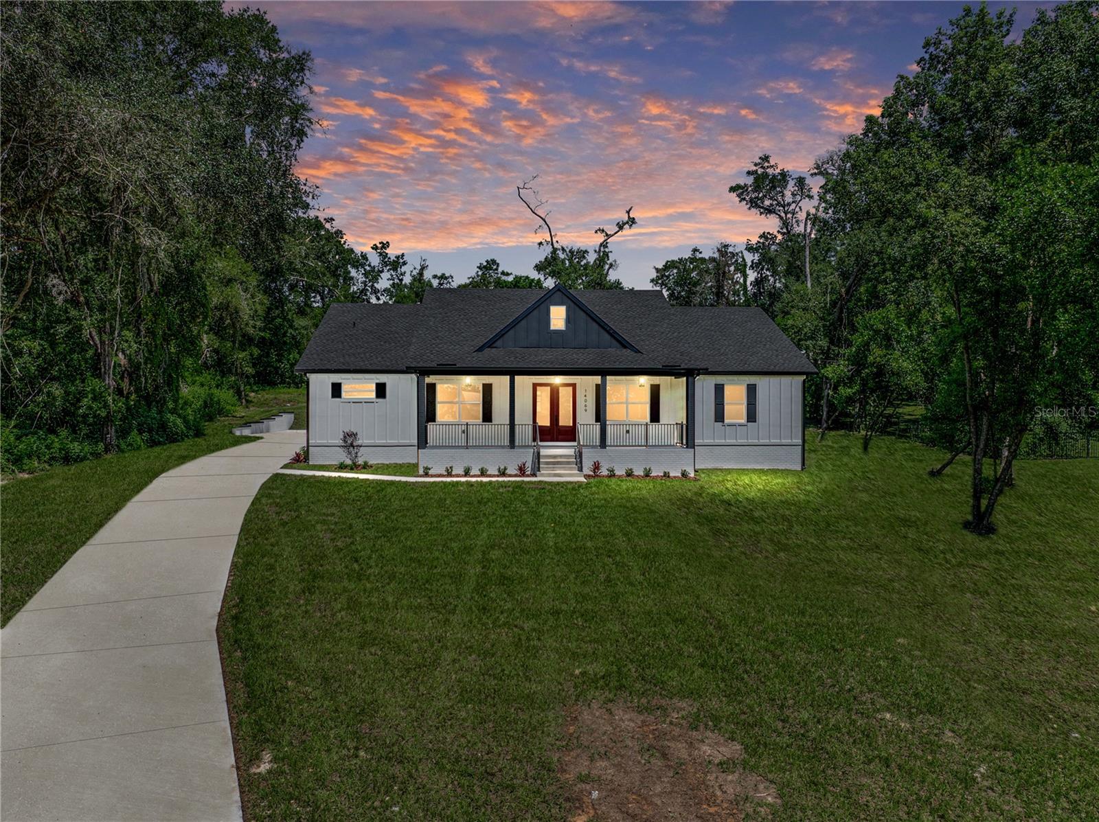 A fresh life of luxury begins in this remarkable 3,197 sq ft custom home built in 2025, perfectly
placed at the end of a cul-de-sac within an intimate eight-home community. Sitting on just over
an acre, close to all that Dade City has to offer, this 5 bedroom, 4 bath, 3 car garage property
delivers a thoughtful layout, high-end finishes, and plenty of space indoors and out with 4,667 sq
ft under roof. A charming front porch greets you with classic board-and-batten accents, modern
colors, and just the right touch of farmhouse character. Inside, soaring vaulted ceilings with
warm wood beams immediately draw the eye upward, setting the tone for the expansive open
layout. Luxury wood-look vinyl plank floors run seamlessly throughout much of the home,
connecting the living room, dining area, and chef’s kitchen into one flowing, light-filled space.
Large sliding glass doors open to a generous covered back porch, extending your living space
outdoors for easy entertaining or quiet evenings. The kitchen was designed for beauty, function,
and entertainment, featuring striking two-toned cabinetry with matte black hardware, a built-in
double oven and microwave, a cooktop, a stainless steel dishwasher, and a refrigerator. A
massive center island offers breakfast bar seating, while glass-faced upper cabinets and a
spacious walk-in butler’s pantry provide abundant storage and display space. Privately tucked
near the front of the home, the first of two suite-style bedrooms offers a one-of-a-kind retreat. Its
spa-inspired bathroom includes a dual-entry walk-through shower, a freestanding soaking tub,
two separate vanities, and a large custom-organized walk-in closet. Down the hall are a full guest
bath, a guest bedroom or office, and a well-appointed laundry room. On the opposite side of the
home, a third bedroom with its own private ensuite and walk-in closet offers plenty of privacy,
while two additional bedrooms share a beautifully designed Jack and Jill bath with dual sinks
and a walk-in shower. The oversized three-car garage is ideal for car enthusiasts or anyone who
values extra space. Every detail in this home
was carefully chosen to create a truly fresh start for its very first owner. Contact us today to
arrange your private showing and experience this exceptional property for yourself.