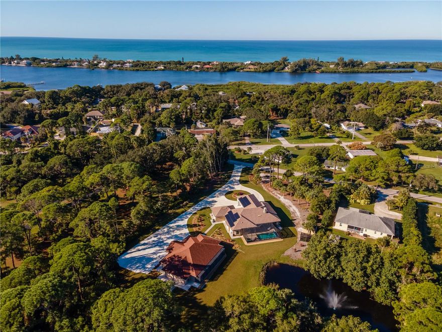 This estate embodies the essence of Florida luxury living — serene water views, expansive entertaining spaces, and impeccable finishes throughout. Whether envisioned as a private family compound, boutique hotel, Airbnb, corporate retreat, or assisted living facility, the property’s Mixed-Use designation unlocks incredible possibilities. Step into a world of elegance and opportunity with this magnificent Northern Englewood compound, a rare sanctuary that seamlessly blends luxury living, income-producing potential, and future development possibilities. Completed in 2021, this custom-built estate is more than a residence — it is a private resort-style haven, featuring a grand main home and guest house with a combined 9 bedrooms and 7 bathrooms, currently operating as both a distinguished private residence and a boutique hotel. You will find that this superb property offers over 7,000 sq. ft. of refined living space with a wood-burning fireplace, an attached 3-car garage, as well as parking for 15+ vehicles on an expansive concrete drive across 4.5 acres of manicured grounds. Mixed-Use approved zoning for unmatched versatility, along with Dual Income potential: boutique hotel or wedding and event venue. Located just 0.9 miles from Manasota Beach, offering coastal convenience and Category 5 storm-standard construction on secure 20-ft. elevation and a private solar farm delivering near-zero energy costs ($28 monthly connection fee only). Enclosed solar-heated, saltwater pool with designer non-slip decking that is always cool underfoot and multiple outdoor kitchens perfect for entertaining. All these features are set amid lush, professionally landscaped grounds, including a tranquil pond with fountain views and a romantic pergola for any event you might envision.  This estate is being offered fully furnished, turnkey, including premium appliances and curated decor, so let's make your vision a reality! This estate embodies the essence of Florida luxury living!