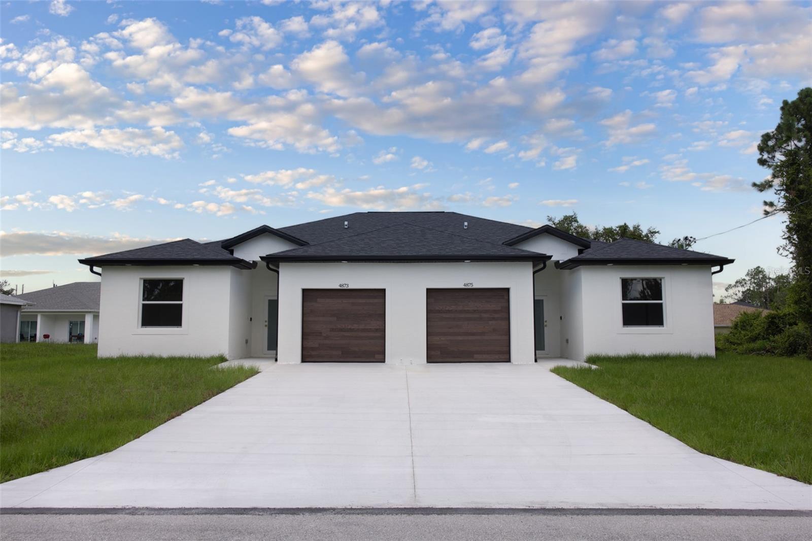 This brand-new 2025 duplex combines thoughtful design with standout finishes. Each unit ~1,195 sq. ft with 3 bedrooms, 2 bathrooms, and a single-car garage. Interiors feature porcelain tile floor throughout, stainless steel appliances and custom cabinets, while the primary suites include double vanities, high-pressure Kohler showers, and striking tile in the bathrooms. Oversized triple sliding doors open to lanais positioned far apart for maximum privacy. Builder provides a 10-year structural warranty + incentives available!