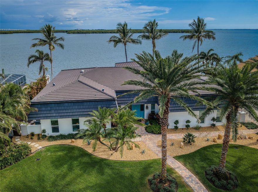 No flooding during storm. Ready for immediate occupancy. Seller will consider selling furnished for additional price.
LOCATED IN ONE OF THE FINEST BOATING COMMUNITIES IN FLORIDA, THIS SPACIOUS, SINGLE-LEVEL 4 BEDROOM 4 1/2 BATH LUXURY ESTATE RESIDENCE DELIVERS SPECTACULAR WATERVIEWS ACROSS ITS WIDE 131FT OF WATER FRONTAGE! Beautifully landscaped with towering Date/Coconut Palms, this remarkable home enjoys wonderful open spaces and a dedicated private courtyard. Beyond its graceful entry foyer and open living area, you’ll be drawn to gorgeous open water views and a dazzling infinity pool that seemingly spills into the waterway! Inspiring tilework, shiplap wall finishes, superior woodworking, and exceptional attention to detail give a lasting, lavish appeal. Grand waterfront living room with built-in surround sound transitions to large open dining. The remarkable gourmet kitchen is a sumptuous culinary delight, with exquisite coastal-white beaded-board cabinetry, graceful granite counters, elevated breakfast bar, Bosch stainless steel cooking center, and full-size pantry. Waterfront family room with spacious casual dining provides a splendid custom-built credenza. Elegant full guest bath doubles as the pool bath. Waterfront owner’s suite opens to the pool deck and features opulent wall/window treatments and spacious walk-in closet system. The lovely owner’s bath boasts granite surfaces, dual vanities, dedicated cosmetics center, hi-end fixtures, and an impressive walk-in, multi-head glass shower enclosure. 2nd and 3rd bedroom suites are oversized and private, with excellent closet systems and plush full baths. Ideal as an office/den, the 4th bedroom has rich built-ins and well-designed closet/storage. Large indoor laundry includes extensive quartz counter space, built-in wash basin, tremendous cabinetry storage, and separate closet. Step out back and discover a stunning, brilliantly-tiled, Pebbletec infinity pool surrounded by a huge travertine paver deck – all looking out to the open water. The deck/pool are elevated and the pool is supported by commercial-grade equipment. The deck offers 400sqft of covered area – perfect for outdoor dining/lounging. Composite deep-water dock with southern exposure - supports a 16K lb boat lift, jet ski lift & slip for a large cruiser. Home has extensive storage, electronic storm shutters & many updates. Best commuting waterfront location in Tampa Bay. Close to I275 - reach the beaches in 4 min, downtown St. Pete in 10 min, Tampa Airport in 25 min. An outstanding luxury value in a premier location! Buyer to verify dimensions.