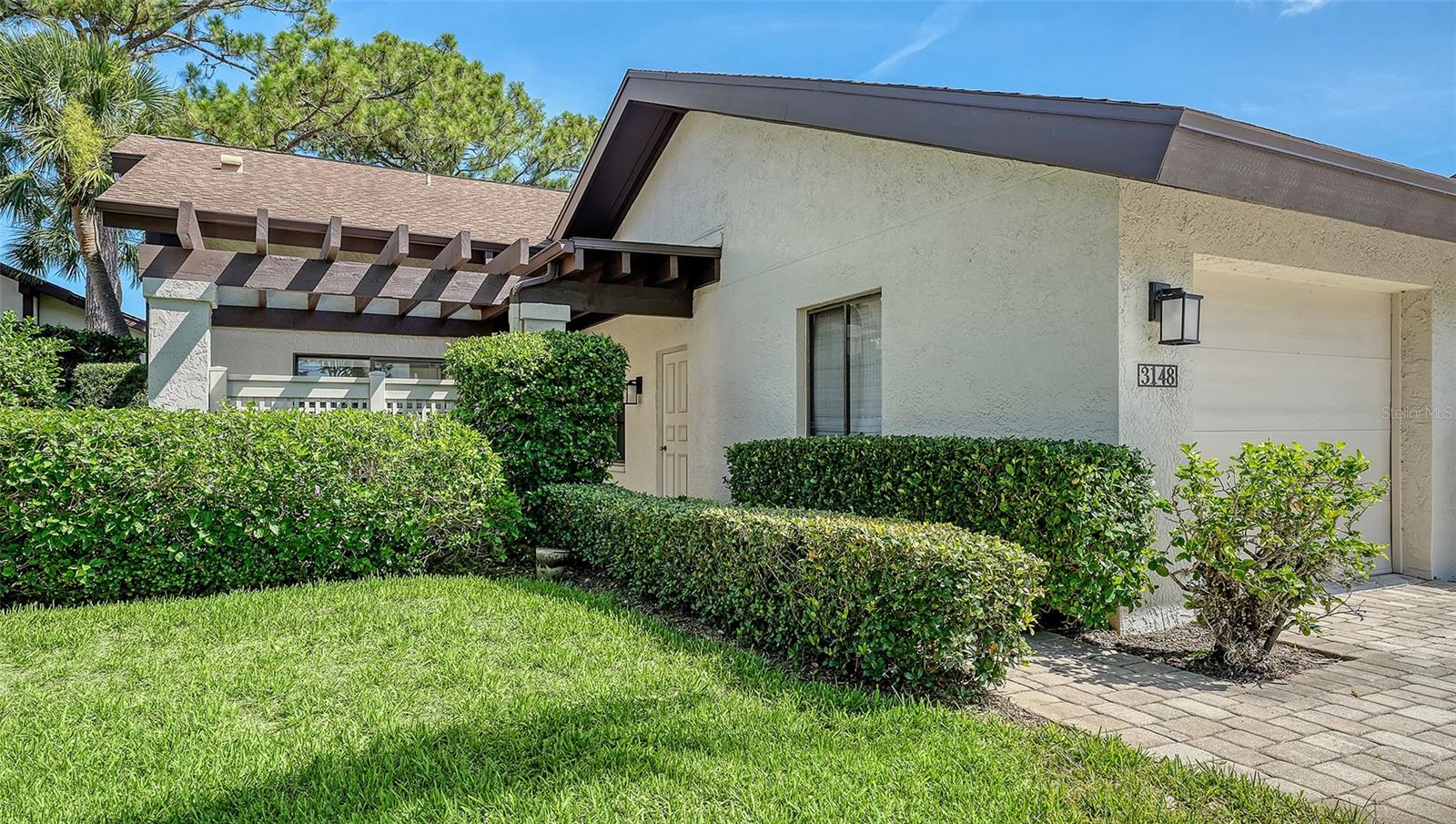 Beautiful end-unit with privacy and a 1-car garage in The Meadows, one of Sarasota’s most desirable neighborhoods just 15 minutes from downtown. Tropical landscaping and a paver patio with charming pergola welcome you home. Inside, you will love the cathedral ceilings, natural light, tall windows and walls of sliders that bring the outdoors in. The kitchen features off-white soft-close white shaker cabinetry, gorgeous quartz countertops, a wide opening into the great room and sliders to the grilling patio. Relax in the primary suite with pond views, walk-in closet, double vanity and glass enclosed shower. All with partial pond views, a block to both heated community pools, and a mile to all the fun The Meadows has to offer. A five-star location on 1,600 park-like acres, The Meadows is a resort lifestyle community 15 minutes from downtown. Residents enjoy 14 miles of biking and hiking trails, fun-filled activities, a fitness center, a Jr. Olympic pool, pickleball courts, and pay-to-play in a top-notch tennis complex. Its prime location places you near award-winning beaches, remarkable arts and culture, Nathan Benderson Park, the upcoming MoteSEA Aquarium, Sarasota Orchestra, Whole Foods, Trader Joe’s and The Mall at University Town Center: a world-class shopping, entertainment and dining destination. A fabulous Florida lifestyle awaits! 2019 shingle roof, 2025 PGT impact dining room window, above flood plain in zone X.