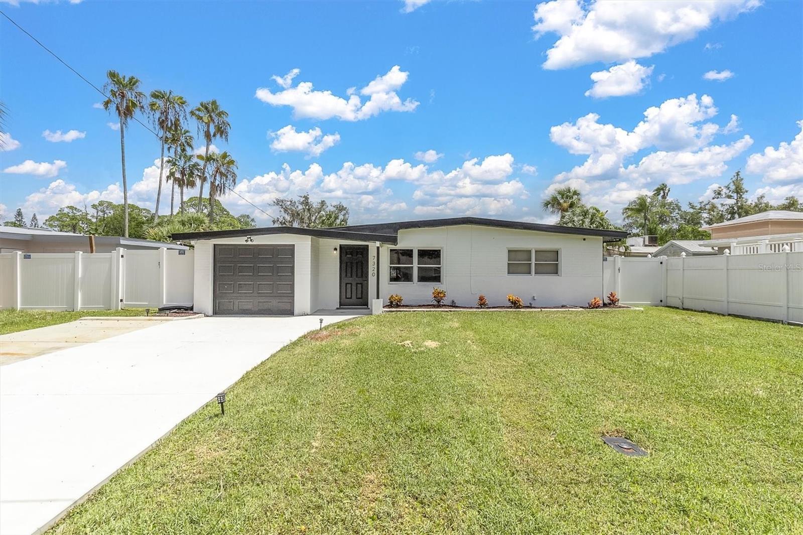 Charming lakefront home in the heart of New Port Richey! This 2-bedroom, 1-bath residence offers 936 sq ft of living space plus a versatile bonus room overlooking the water. Built in 1958 with solid block construction, the home features a bright living area, updated laminated/tile flooring, and central air. Gorgeous modern kitchen featuring brand-new white shaker cabinets with sleek black hardware, complemented by stunning quartz countertops with bold waterfall veining for a true designer touch. The full-height glossy subway tile backsplash adds texture and brightness, perfectly paired with stainless steel appliances including a range, built-in microwave, and dishwasher. A deep stainless steel sink with a matte black pull-down faucet offers both style and functionality. Recessed LED lighting illuminates the space, while the elegant marble-look tile flooring ties the design together. This kitchen is a perfect blend of contemporary elegance and everyday practicality, ready for both gourmet cooking and stylish entertaining. The backyard opens to serene lake views and is perfect for relaxing or entertaining. It has a 1-car attached garage, no HOA or CDD, and a golf-cart friendly neighborhood close to beaches, parks, shopping, hospitals, and Tampa International Airport. The home comes with a one-year Home Warranty, with an accepted contract before September 5, 2025.