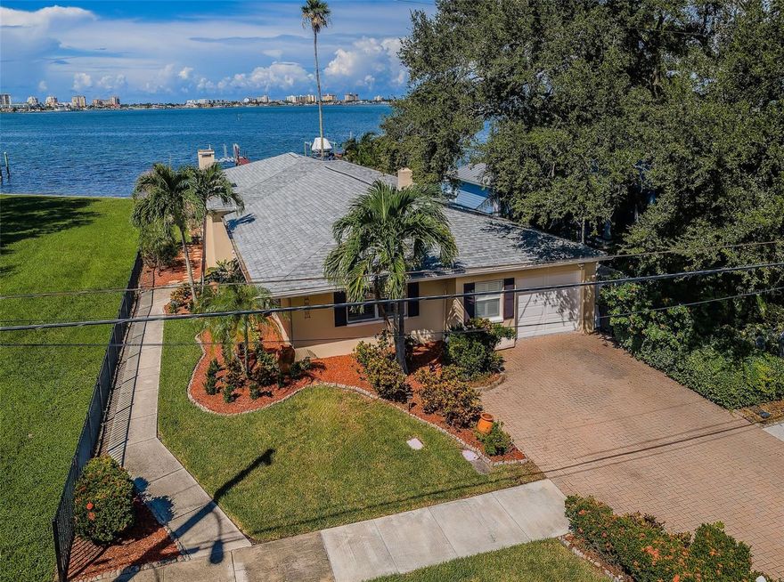 THIS WONDERFUL WATERFRONT HOME FEATURES SPECTACULAR OPEN WATER VIEWS OF CLEARWATER HARBOR AND THE INTRACOASTAL WATERWAY!  Perfectly situated between downtown Clearwater and downtown Dunedin, you’ll have an easy boat ride from your dock to Sand Key to your south and renowned Caladesi and Honeymoon Islands to your north.  Richly landscaped and beautifully maintained, this cute coastal-bungalow residence delivers an intimate, private waterfront living experience.  The entry foyer opens to elegant living and family areas overlooking the waterfront.  A finely-appointed fireplace/entertainment center enjoys superb built-ins and lavish finishes.  Beyond its high-quality French doors, step out to a magnificent 500sqft covered/elevated waterfront deck that boasts exquisite wood ceilings and stunning freeform-pattern, triangular-shaped, clay tile flooring!  The chic casual waterfront dining area is complemented by a full-service kitchen with breakfast bar and two pantries.  Both bedrooms are private and sizable and both baths are attractively-finished.  Superb woodworking includes the generous use of nautical-theme beaded-board wainscoting in the living room, dining, and baths, plantation shutters and appealing crown trim-work.  The spacious backyard area includes a large step-up hot tub that overlooks the waterfront.  You’ll enjoy peace-of-mind with a new roof installed in August of 2024.  Updated seawall supports a dock and boatlift, for easy cruising on the water.  Centrally-located between the extensive social activities of downtown Dunedin and Clearwater Beach.  A great place to experience waterfront living!  Dimensions are estimates, buyer to verify dimensions.
