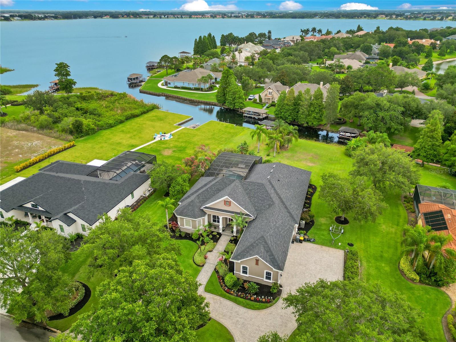 PRICE JUST REDUCED $50,000! With and a new roof from 2023, this home offers its own private, covered, newly updated boathouse with a boat lift providing direct water access via private canal to Lake Winterset and the chain of 16 lakes here in Winter Haven! Legoland is also accessible by boat on Lake Eloise! It also boasts advanced features like tray and coffered ceilings, custom window & door trim throughout, central vacuum system, surround sound, natural gas, a water softener, two tankless hot water heaters, granite countertops, a well for the sprinklers and even a soundproof media room that doubles as a storm shelter! Welcome to 2682 Wyndsor Oaks Place, a luxurious 4-bedroom, 4-bathroom home that sits on over an acre of water front land in Winter Haven’s private, gated, Wyndsor at Lake Winterset community. This stunning property features 14-18 foot ceilings upon entry, an open floor plan, and a large open kitchen perfect for hosting and entertaining. The master suite includes an en-suite bathroom with a soaking tub, walk-in wrap around dual showers, dual vanities, and TWO spacious walk-in closets! Enjoy additional flex space in the main foyer, a family room that doubles as a game room, as well as a soundproof media room that doubles as a storm shelter. Relax by the large screen-enclosed pool & spa with PebbleTec finishes and beautiful views of Lake Winterset in the background, while also enjoying your outdoor kitchen! The 3 car garage provides ample storage space. Located in a private, gated community with amenities including a tennis court, half a regulation size basketball court, as well as a playground, this home is just minutes from downtown Winter Haven, offering both tranquility and convenience. Don’t miss the chance to own this lakeside retreat. Contact us today to schedule a private showing and experience the elegance and comfort of 2682 Wyndsor Oaks Place!