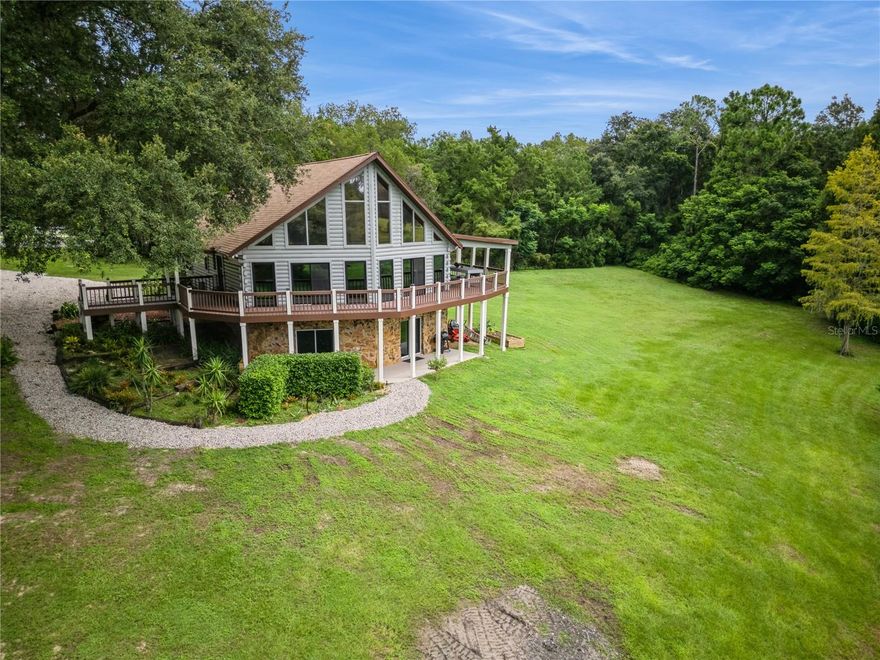 Near the Ocala forest for hunting, fishing and awesome horseback riding! Stunning custom built 3 story log cabin with wrap around decks sitting on 3 acres with scenic waterfront view. Beautifully done with all the amenities! 4800 heated sq ft with 4 bedrooms, 3 full baths. Multiple Zoned heating and cooling system with 2 units. The flooring is a mix of ceramic tile and gorgeous bamboo wood. Thermal Anderson windows,  and recessed lighting everywhere. Main floor has 2 bedrooms, bath with laundry, great room, and custom built island. Access to the wrap around deck is accessible through BRAND NEW custom sliding doors off the great room. Kitchen is equipped with wood cabinets with self closing drawers, gas cooktop, dual electric ovens, under the counter lighting and more. The 700 sq ft Master suite with loft is on the 3rd floor overlooking the stunning main floor and has a bathroom with a large walk-in shower, whirlpool tub, two sinks and skylight. The walk out basement has a great room, kitchenette, full bath and large bedroom. Let your imagination run wild with the 2 huge bonus rooms down there! Could be an in-law suite, rental income, hunting/fishing lodge or just space for your large family activities!