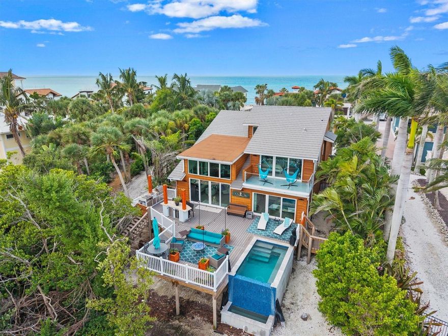 Step into a world where the horizon meets the sea and every sunset paints a masterpiece. This exceptional cedar-sided residence on exclusive Casey Key offers the perfect blend of contemporary elegance and natural beauty along an eight-mile stretch of pristine shoreline. The home features three spacious bedrooms, each with a private ensuite, plus a beautifully appointed half bath on the lower level. The open-concept living area is flooded with natural light and showcases soaring vaulted ceilings, creating a sense of space and serenity. Brand-new engineered hardwood floors add warmth and sophistication throughout. The chef-inspired kitchen is a showpiece, complete with a stunning backsplash, quartz countertops, and high-end stainless steel appliances—ideal for both culinary creativity and entertaining. A stylish dry bar with full-view leaded glass and a modern barn door adds a perfect touch of charm and convenience. Glass doors open to a large composite deck overlooking tranquil waters, providing an ideal setting for gatherings or quiet relaxation. The infinity-edge pool enhances the seamless connection to the waterfront, offering an unrivaled sense of luxury. A private stairway leads to your deeded dock and assigned boat slip with direct access to the Intracoastal Waterway. The dock is currently being assessed for hurricane-related repairs, with quotes underway. Upstairs, a versatile loft offers space for a den, office, or sitting area with sweeping views of the main living area. The primary suite boasts panoramic views of Little Sarasota Bay, while the second bedroom features a private outdoor sitting area, perfect for enjoying the sounds of the Gulf and the surrounding natural beauty. Sleek modern infinity edge pool with underwater seating and massage jets allows you to relax the day away! This residence is both secure and smart, featuring a state-of-the-art security system with optional local police connection and advanced home automation for lighting, climate, and security. Designer window treatments and thoughtful architectural details complement the home’s refined modern aesthetic. Casey Key offers the ultimate in island living, from kayaking and jet skiing on the bay to walking or cycling past the island’s scenic multimillion-dollar estates. Enjoy boating, fishing, dolphin watching, and quick access to Sarasota’s renowned beaches, fine dining, shopping, and cultural attractions. Conveniently located near I-75 and just 10 minutes from private aviation at the Island of Venice, this property combines serene coastal living with unmatched accessibility. Don’t miss this rare opportunity to own a stunning waterfront retreat on Casey Key. Schedule your private showing today and experience the pinnacle of coastal luxury.