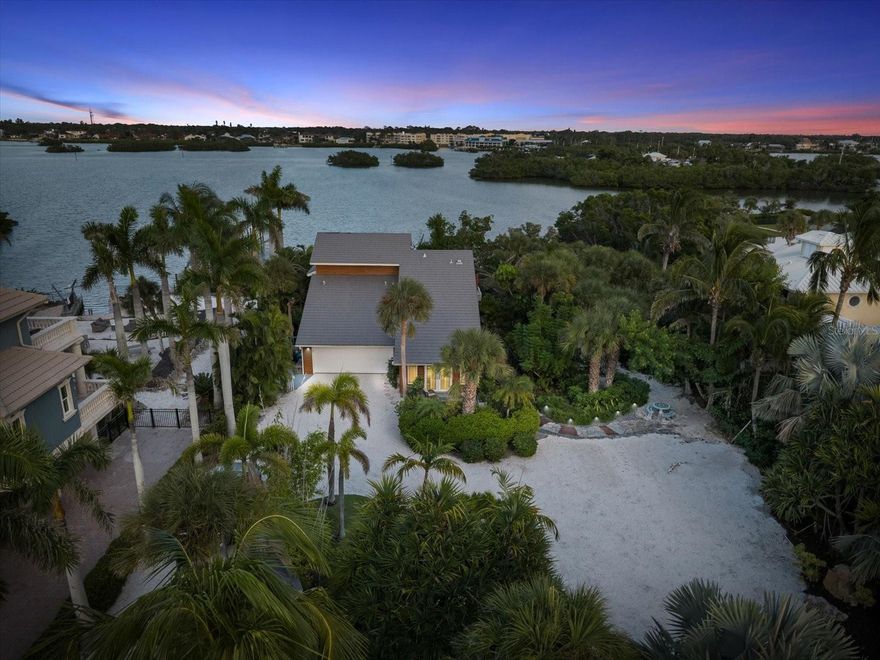 Live the ultimate coastal lifestyle on the coveted Casey Key barrier island at this vibrant 3-bed, 3.5-bath waterfront retreat, perfectly positioned along the Intracoastal Waterway with dazzling, front-row views. Designed for unforgettable days on the water, this home features a stunning Aqua-Tech infinity edge heated pool with therapy jet ledge, where you can unwind while watching boats, jet skis, kayaks, and the occasional dolphin glide by.

Set on a generous .49-acre lot with lush tropical landscaping, fresh exterior lighting, brand-new shell driveway, and beautifully re-stained cedar siding (2025), the home blends island charm with modern updates. A shared, deeded boat slip offers quick access to the Intracoastal—perfect for sunset cruises, fishing trips, or lunch runs to nearby waterfront restaurants.

Step inside to soaring ceilings and sun-filled living spaces anchored by gorgeous engineered hardwood floors. The open-concept great room flows effortlessly to an expansive composite deck designed for entertaining, complete with multiple lounge zones, a grilling area, and panoramic water views that make every gathering feel like a vacation.

The chef's kitchen shines with sleek cabinetry, premium stainless appliances, a dramatic stone island, and a glass tile backsplash. A stylish dry bar with leaded glass barn door adds an extra touch of coastal chic. All three bedrooms with their own private ensuites, while the loft provides flexible space for an office, den, or artist’s perch overlooking the main living area.

The metal tile roof provides long-term durability, and the optional HOA (only $400) adds neighborhood security without CDD fees. Enjoy peaceful island living with the convenience of Blue Lagoon Restaurant, Mariner Jack Marina, boat and jet ski rentals, fishing spots, and Sarasota’s vibrant dining and cultural venues just minutes away. Private aviation is close by, making travel effortless.

Experience waterfront living at its most energizing and serene on one of Florida’s most treasured islands. This is Casey Key—where every day feels like a getaway.