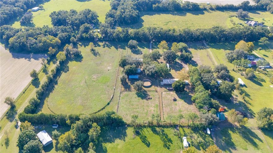 12-Acre Horse Farm with Two Barns and Training Track! This 12-acre horse farm is set up and ready for immediate use. The property includes two barns — the main barn with 12 stalls and a second barn with 8 stalls. Both barns have electricity and running water. There are five paddocks, a round pen, a feed shed, and a covered sounding board area suitable for Paso Fino enthusiasts. The property also features a 3/8-mile training track, ideal for Thoroughbreds, Quarter Horses, or other training purposes. The residence is a double-wide manufactured home with approximately 960 sq. ft. of living area. It includes laminated floors throughout, walk-in showers in both bathrooms, and a kitchen with ample cabinet space and an eating area. A 22’ x 24’ game room provides additional space for recreation, family events and more. The front deck offers a comfortable spot to relax or entertain guests. This property provides a practical setup for horse training, breeding, and/or boarding operations. FOR ADDITIONAL INFORMATION CALL/TEXT LISTING AGENT JOHN OCASIO