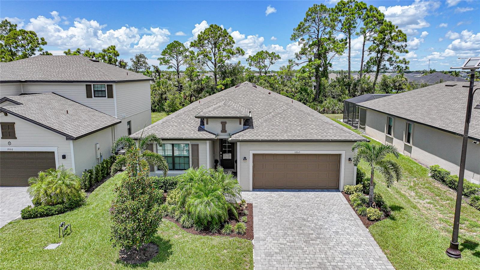 Welcome to a true showstopper in the coveted community of West Port—where modern elegance meets effortless Florida living and every day feels like a vacation. This immaculate 3-bedroom, 3-bathroom home with a versatile den and a spacious 2-car garage offers over 2,000 square feet of pure perfection. Built in 2022, it combines the best of like-new construction with thoughtful upgrades, including elegant tile flooring throughout, a light-filled open layout, and high-end finishes that make every space feel warm and inviting. At the heart of the home, the gourmet kitchen opens seamlessly to the dining and living areas, creating the perfect flow for hosting family and friends. The expansive screened lanai is the ideal spot to start your day with coffee or unwind in the evening, as it overlooks a tranquil freshwater canal where breathtaking sunsets paint the sky in stunning colors. The private primary suite is a retreat in itself, complete with his-and-hers closets and a spa-inspired bathroom designed for ultimate relaxation. Each guest bedroom offers its own beautifully appointed bath, giving visitors the comfort and privacy they deserve. Step outside your door and experience the best of West Port living. This master-planned community features a sparkling resort-style pool, scenic walking and biking trails, lush green spaces, and recreational areas designed to keep you active and connected. Whether you’re enjoying a swim, meeting neighbors at community events, or exploring the natural beauty of the surroundings, West Port offers amenities that elevate everyday life. Back at home, a fenced backyard provides the perfect place for pets to play or for you to enjoy a quiet afternoon. The HOA maintains your yard, so you can spend more time living the Florida lifestyle instead of working on it. And with this home being sold fully furnished with stylish, high-quality pieces, you can simply bring your suitcase and start enjoying it from day one. With its prime location, captivating water views, full suite of community amenities, and a move-in-ready design that’s as beautiful as it is functional, this isn’t just a home—it’s your dream come true.