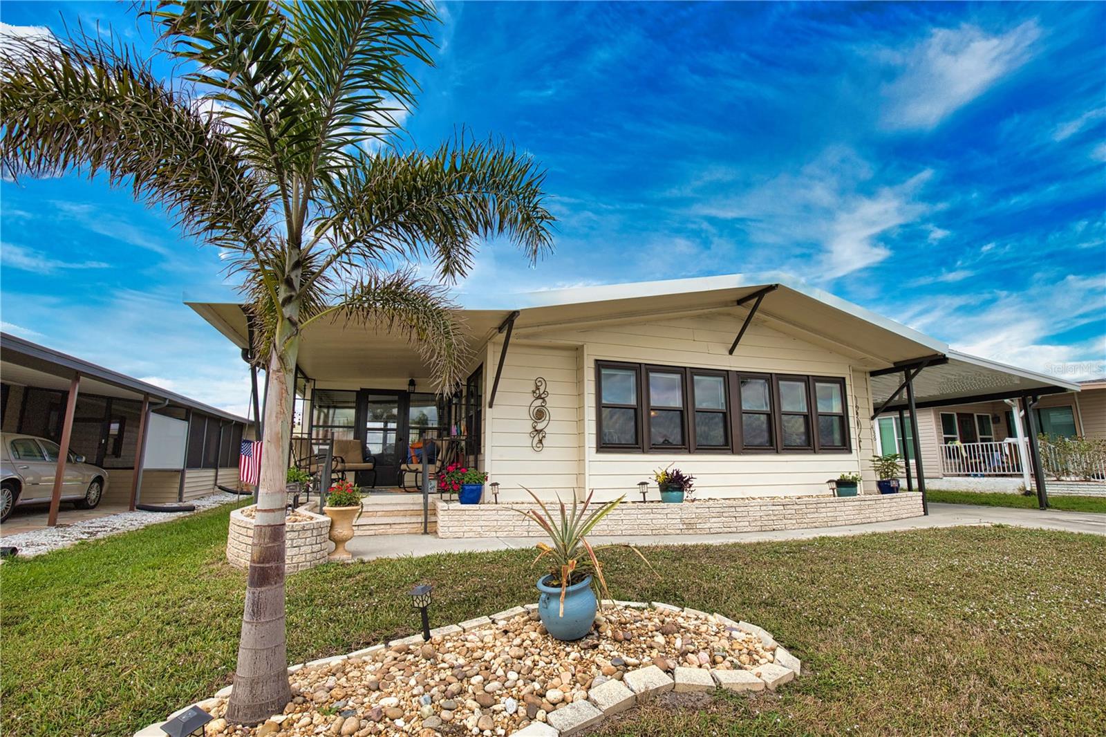 If you’re seeking a luxurious home with breathtaking lake views, look no further! From the moment you enter, you’ll be captivated. The welcoming entryway leads to a spacious kitchen and family room featuring a stunning center island and ample cabinet space. The cozy family room flows into an exquisite under-air Florida room, perfect for entertaining, with a pass-through window to the kitchen and three walls of windows that fill the space with natural light. For special occasions or simply enjoying the view, the elegant living room offers sophistication. The primary bedroom is a serene retreat with an updated ensuite bathroom that includes double sinks, a walk-in shower, and two generous closets. Guests will feel pampered in the comfortable guest bedroom with a walk-in closet and an updated Jack-and-Jill bathroom. Embrace the outdoors from the serene lanai or charming open porch, both offering stunning views and the soothing sound of a fountain. This exceptional home truly embodies the Florida dream! Key features include 11 impact windows, a new roof (2024), efficient air conditioning (2020), and a modern carport (2024). The home is being offered partially furnished, ready for your personal touch.
Welcome to La Casa, an enchanting community where 974 exquisite homes are beautifully set among native trees, surrounded by spacious common areas and eight serene lakes. Our generous 60 by 80-foot lots offer your ideal space. Perfectly located between Sarasota and Fort Myers, La Casa is a boater's paradise with direct access to the stunning Gulf of Mexico. Enjoy easy access to shopping, sightseeing, golfing, and fishing, all while immersing yourself in the rich culture of Southwest Florida. Experience the warmth of Southwest Florida’s winters in a relaxed environment, far from the east coast hustle. Our lush, mature landscaping reflects the dedicated care of residents and management. La Casa features some of the finest pools in the area, including our magnificent 40 by 60-foot swimming pool, maintained at a delightful 87 degrees, and a cozy 20 by 40-foot pool nestled between the clubhouse and Activity Building, both with inviting hot tubs. Stay connected with our complimentary Wi-Fi at the Clubhouse, Activity Building, and Recreation Hall while you soak up the sun. La Casa is a family-friendly haven where you can enjoy tranquility while remaining close to vibrant attractions. Come visit our charming oasis and discover why La Casa is the ultimate destination for snowbirds and year-round residents!