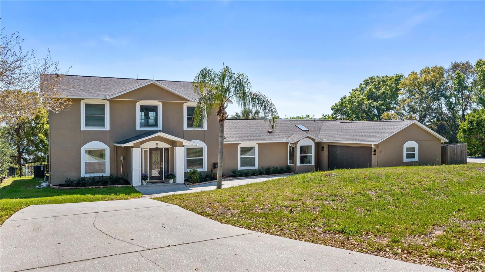 Gorgeous Montverde home, incredible lake views and pool. In the heart of Montverde near the renowned Montverde Academy, this stunning pool home offers a serene retreat with panoramic views of Lake Florence and surrounding hills. With meticulous renovations throughout, every detail has been thoughtfully designed to maximize comfort and style, creating the ideal blend of luxury living and natural beauty. As you approach the home, a circular driveway welcomes you to this spacious residence. The family room, at the heart of the home, is ideal for relaxing and entertaining, with views of the lake and plenty of room for a large sectional and flat screen TV, and with the open concept design, it flows effortlessly into the formal dining room, which also boasts spectacular views. The gourmet kitchen is a showstopper, designed with functionality and aesthetics in mind. A skylight and a charming bay window in the breakfast nook fill the space with natural light. The stunning granite countertops, including a dramatic waterfall edge and bar seating for four, provide ample space for meal preparation, featuring custom cabinetry, beverage area, drawers with plenty of storage, and a pantry cabinet with convenient pullout drawers. Stainless steel Samsung smart appliances, a Kohler enameled cast iron sink and sleek finishes complete this culinary haven, making it the space for casual and formal dining. Five bedrooms in total, on the main floor, you’ll find a private bedroom ideal as a second primary suite, with sliding glass door and direct access to the pool area, en-suite bath, walk-in closet and a beautifully remodeled bath with tiled shower. Three additional bedrooms are also on the lower level, including one larger room with a picture window showcasing more of the stunning lake views. This room provides direct access to the pool area, ideal for enjoying the outdoors. The third bath features dual vanities and a tiled tub and shower. The primary suite is a sanctuary, offering a luxurious retreat with unrivaled lake and hillside views. This massive bedroom features a cozy fireplace and a private screened-in balcony where you can enjoy your morning coffee or unwind with an evening beverage. The wet bar, complete with sink and refrigerator, adds an extra touch of convenience to this remarkable space. Two walk-in closets ensure you’ll have plenty of storage. The bath is absolutely fabulous, with freestanding tub ideally positioned near the large picture window to take in the sweeping lake views. A walk-in tiled shower with dual shower heads including a rain head, bench and frameless glass doors, provides a spa-like experience. Step outside to your private paradise, where the sparkling pool is framed by landscaping and both the expansive covered, screened-in porches, perfect for alfresco dining or lounging and offer unobstructed views of the picturesque hillside and Lake Florence. Whether you’re taking a dip in the pool or simply relaxing in the serene surroundings, this outdoor space is the ideal place to enjoy Florida’s natural beauty. With newer roof, tankless water heater, fresh interior/exterior paint, finished with high-end touches, including smart switches/automated lighting, oversized baseboards, gorgeous flooring, this home has it all. The combination of luxury, comfort and spectacular views makes this Montverde home a once-in-a-lifetime opportunity so don’t miss out on the chance to make this dream home your own!