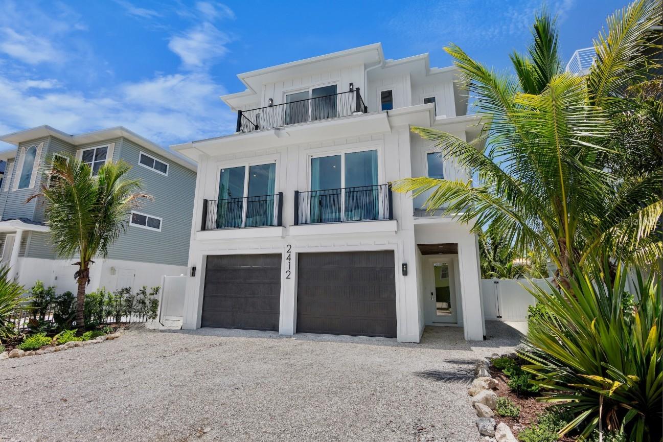 This newly constructed 7 bedroom, 6.5 bath luxury coastal residence, completed in 2025, combines modern design with the relaxed charm of Anna Maria Island and is located just steps from the pristine Gulf shoreline. Thoughtfully designed for both personal enjoyment and high-performing rental income, the home offers a spacious open-concept layout with a beautifully furnished great room that seamlessly connects to an upscale designer kitchen featuring quartz countertops, custom cabinetry, statement lighting, an oversized entertaining island with seating for large groups, and high-end stainless steel appliances. Natural light pours through expansive windows and sliding doors that open to multiple covered balconies, creating a bright and airy coastal atmosphere.
The outdoor living experience is a highlight of the property, with a private heated pool featuring a sunshelf for lounging and a shaded covered seating area beneath the elevated structure that functions as a second outdoor living room. Multiple balconies on different levels provide quiet spots to relax, enjoy morning coffee, feel the breeze, and take in long-range Gulf views. The rooftop deck offers an elevated vantage point for unforgettable sunset viewing and island skyline scenery, giving the property a true rooftop retreat feel.
Each bedroom is thoughtfully appointed to function as an en-suite or semi en-suite, offering privacy and comfort for large families and vacation guests. The bedroom layout was designed with comfort and privacy in mind, offering multiple king suites along with dedicated bunk accommodations. The property is perfectly positioned in one of the most walkable areas of Bradenton Beach, with the Gulf of Mexico only a few steps away and easy access to island shops, waterfront dining, and the laid-back boutique atmosphere that makes Anna Maria Island so sought-after. With a proven track record as a successful luxury vacation rental and turn-key presentation, this home delivers the full package of modern construction, resort-style amenities, and the island lifestyle that brings visitors back year after year.
