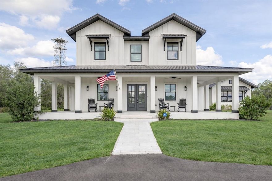 Discover the perfect blend of luxury and tranquility in this stunning 5-bedroom, 3.5-bath modern farmhouse nestled on 7.9 acres within a prestigious gated acreage community. Built in 2023, this remarkable home features an inviting wrap-around front porch, ideal for enjoying peaceful evenings overlooking your own picturesque pond. As you step inside, you are greeted by soaring 18-foot ceilings and dramatic vaulted ceilings in the living room, beautifully accented with wood beams.

The open-concept layout flows effortlessly into a gourmet kitchen designed for both style and function, complete with quartz countertops, sleek white shaker cabinetry, a hidden-door butler’s pantry and dishwasher, and high-end appliances, including a built-in ice machine and wine fridge. Luxurious luxury vinyl flooring and a cozy gas fireplace enhance the refined ambiance throughout.

Retreat to the spacious primary suite, offering a spa-inspired ensuite with a massive walk-in shower, creating the perfect private sanctuary. Step outside to your resort-style oasis featuring a sparkling saltwater pool, elegant travertine tile patio, and a panoramic view screen enclosure that captures breathtaking views of the surrounding landscape—perfect for both entertaining and quiet relaxation.

This exceptional home also includes a 4-car garage, upgraded gemstone lighting accenting the exterior soffits and pool enclosure, a whole-home reverse osmosis water system, and a whole-house Generac generator. With impeccable attention to detail, premium upgrades, and expansive acreage, this modern farmhouse presents a rare opportunity to enjoy luxury living in a serene setting. Don’t miss your chance to own this extraordinary property.