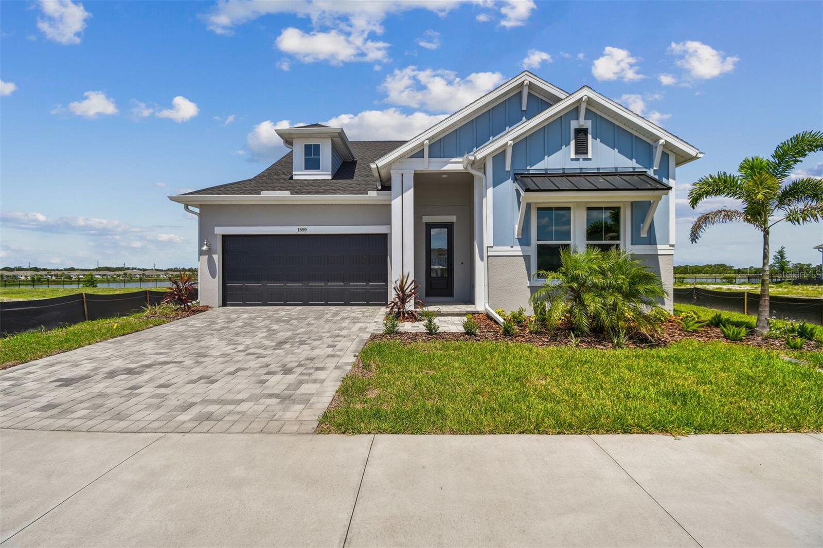 One or more photo(s) has been virtually staged. Live Waterfront Luxury in the Waterline Plan at Emerald Landing – A Lifestyle Like No Other. Welcome to the Waterline floor plan by David Weekley Homes, where thoughtful design, everyday comfort, and elevated living come together in the heart of Emerald Landing at Waterside. Perfectly positioned along peaceful Spoonbill Lake, this home is more than just a place to live—it’s your personal retreat and your ultimate entertaining space. Step inside to a light-filled, open-concept layout that effortlessly connects the designer kitchen, dining area, and family room—creating the perfect backdrop for everything from casual mornings to elegant evenings. The gourmet kitchen features a built-in oven and microwave wall unit, gas cooktop with designer vent hood, and breathtaking lake views through sliding glass doors that lead to your covered lanai. The owner’s suite is a serene sanctuary, complete with a spa-inspired bathroom showcasing a freestanding soaking tub, elegant finishes, and a spacious walk-in closet. Two additional junior bedrooms offer flexible spaces for guests, kids, or creative pursuits, while the enclosed study with French doors is ideal for a home office or cozy den. A well-appointed laundry room with utility sink hook up adds convenience, and the 3-car tandem garage ensures plenty of room for vehicles, hobbies, or extra storage. Every detail has been considered—from impact-rated hurricane windows to the benefits of living in a natural gas community—a true chef’s dream. Outside, enjoy maintenance-free living with all exterior landscaping and irrigation handled by the HOA. You’ll also love access to resort-style amenities, including: A lap-lane pool with shaded cabanas, Pickleball courts, dog park, fire pit, a boat dock with water taxi service to Waterside Place, walking/jogging trails and a beautifully designed multi-purpose community building. Located just minutes from Waterside Place—with dining, shopping, and a weekly Farmer’s Market—Emerald Landing offers the best of Sarasota-Bradenton living. This property offers exceptional quality, energy efficiency, and peace of mind with a comprehensive 1, 2, 10-year warranty. Ready NOW! Schedule an appointment with our sales team to make this home yours!